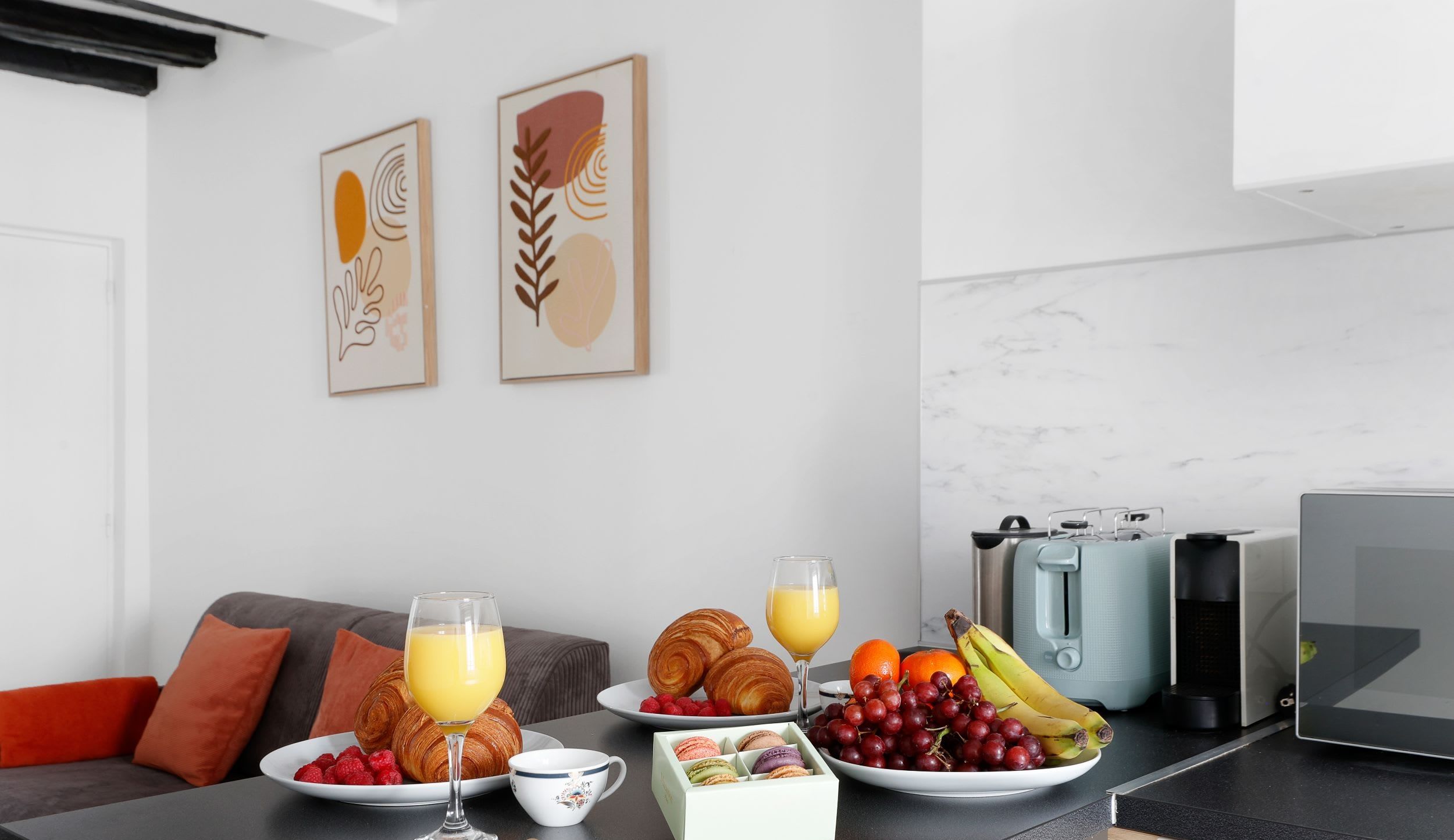 Appartement meublé rue Saint-Séverin Paris 5e, canapé-lit sous des poutres apparentes dans un intérieur du Quartier Latin