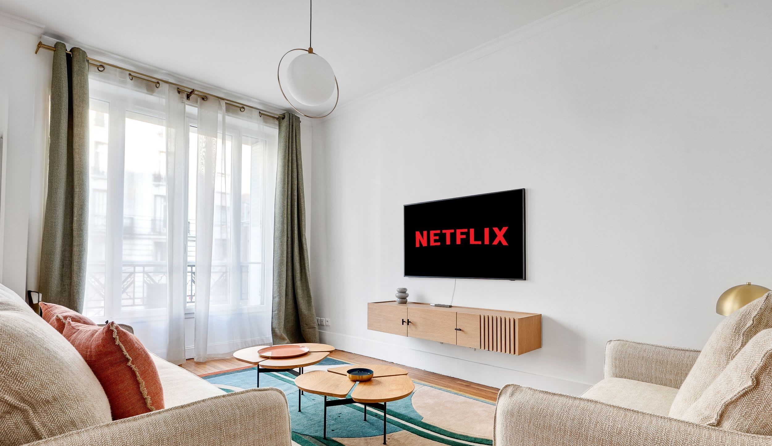 Espace de vie avec canapé confortable, TV connectée et coin repas