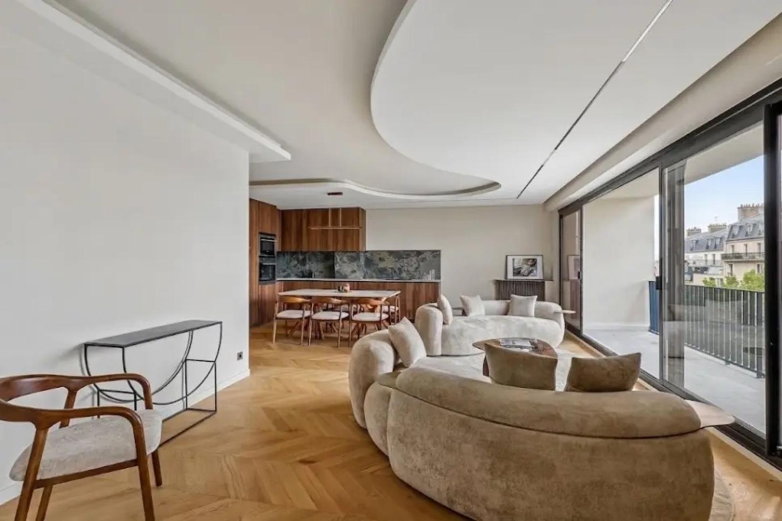 Salon lumineux avec plafond courbe et accès balcon