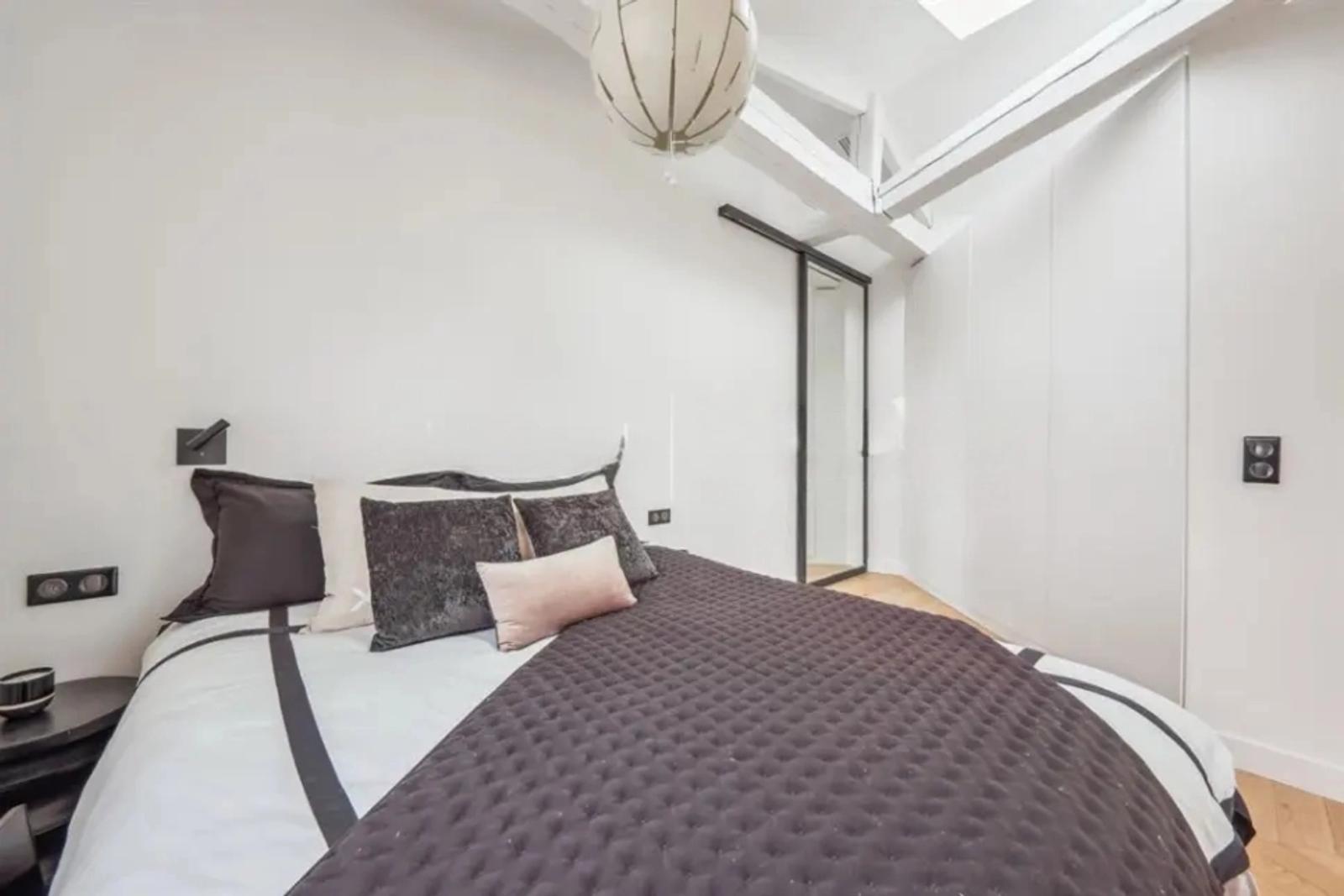 Chambre élégante avec lit double et poutres apparentes