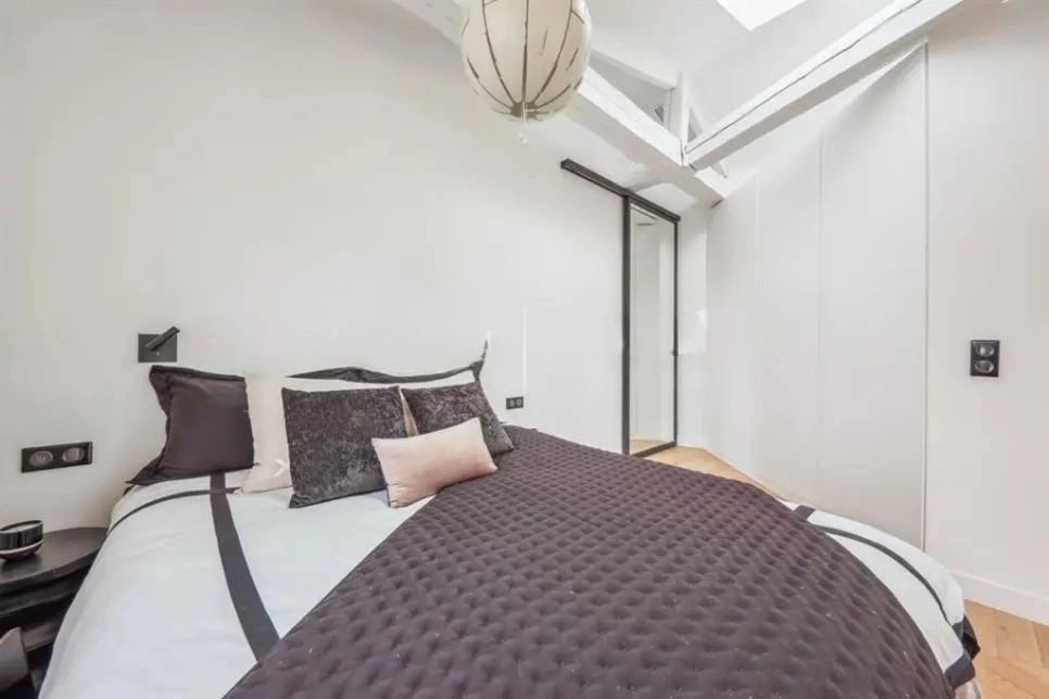 Chambre élégante avec lit double et poutres apparentes