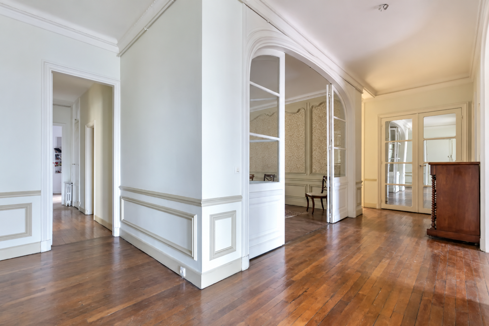 Entrée d'appartement avec arches et parquet