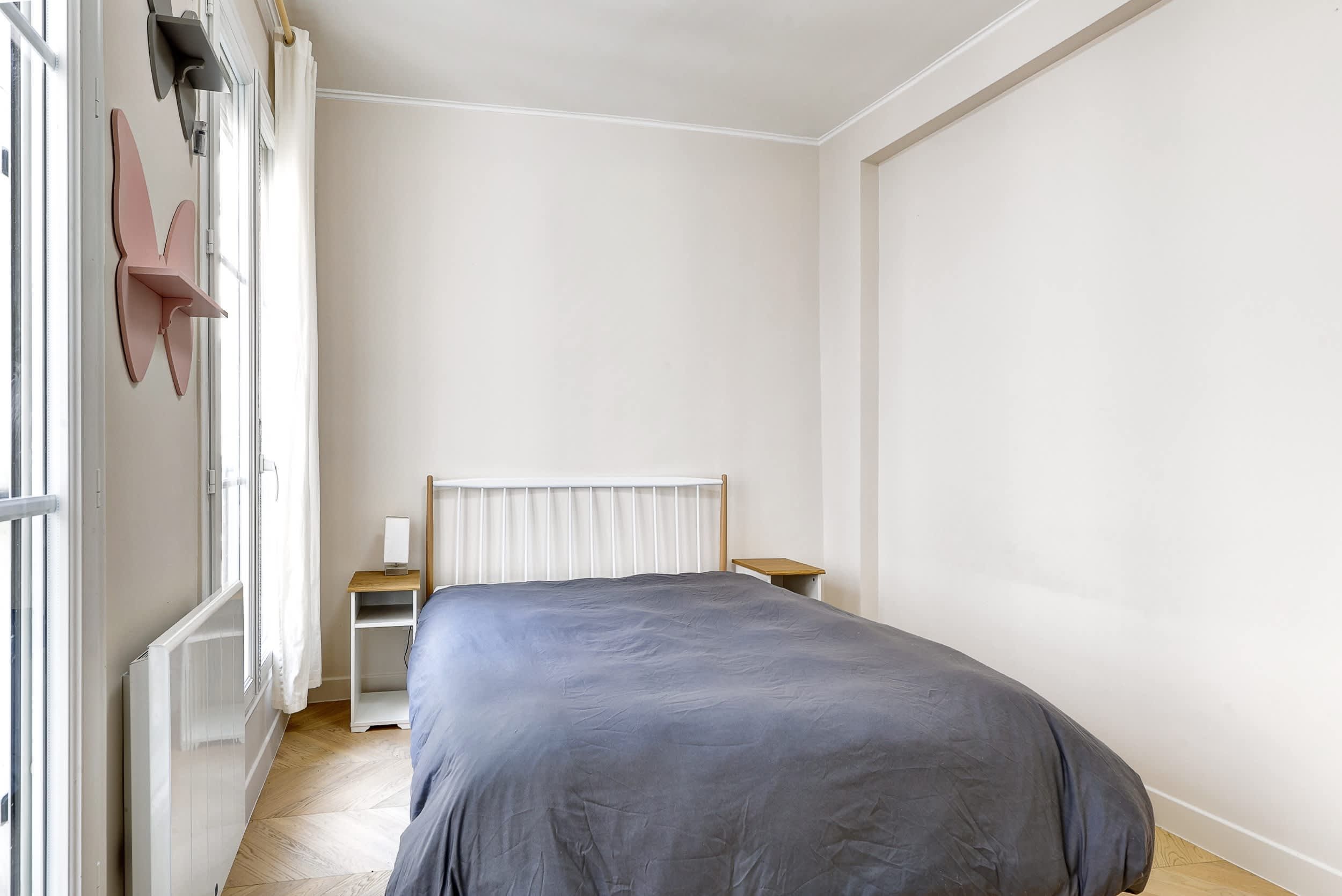 Top-floor Haussmann apartment on rue Meslay near République Paris 3rd, bright dual-aspect living room with designer sofa bed and refined decor