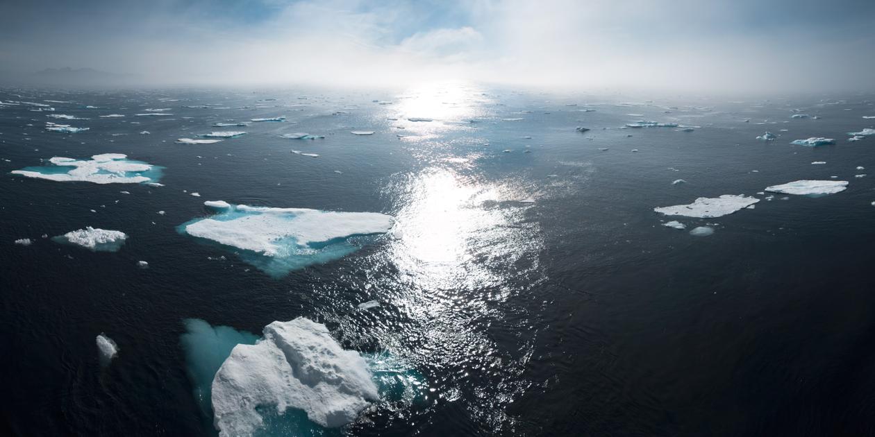 Et bilde av åpent hav med isflak flytende på overflaten.