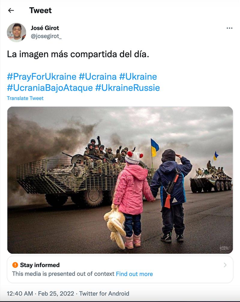 Et skjermbilde av en spansk tweet fra brukeren José Girot @josegorit_. Tweeten er merket med teksten "Stay Informed. The media is preented out of context. Find out more." Den er lagt ut den 26. februar 2022. Det er et bilde av to barn som ser på en militærparade. Det ene barnet gjør en militærhilsen. Teksten i tweeten er "La imagen más compartida del día. #PrayForUkraine #Ucraina #Ukraine #UcrainaBajoAtaque #UkraineRussie"