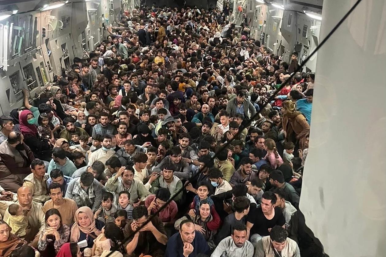 Et bilde av et lastefly som er stappfullt av flyktninger.