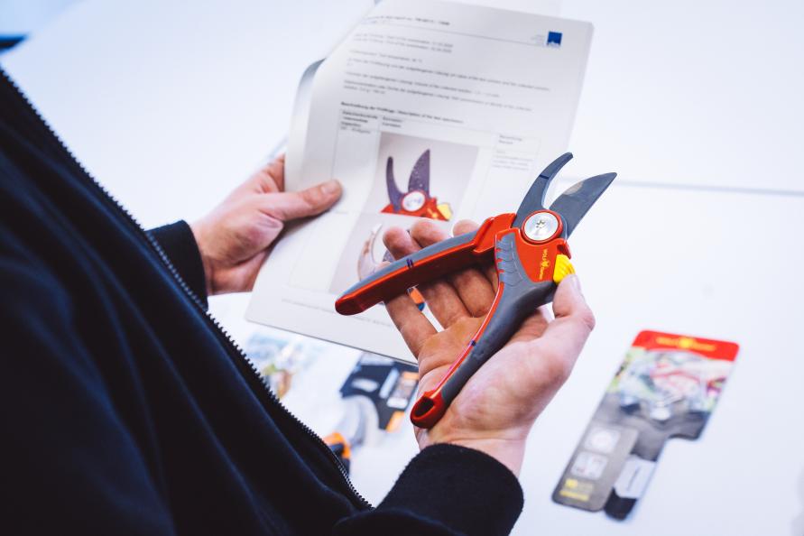 En man håller i en sekatör