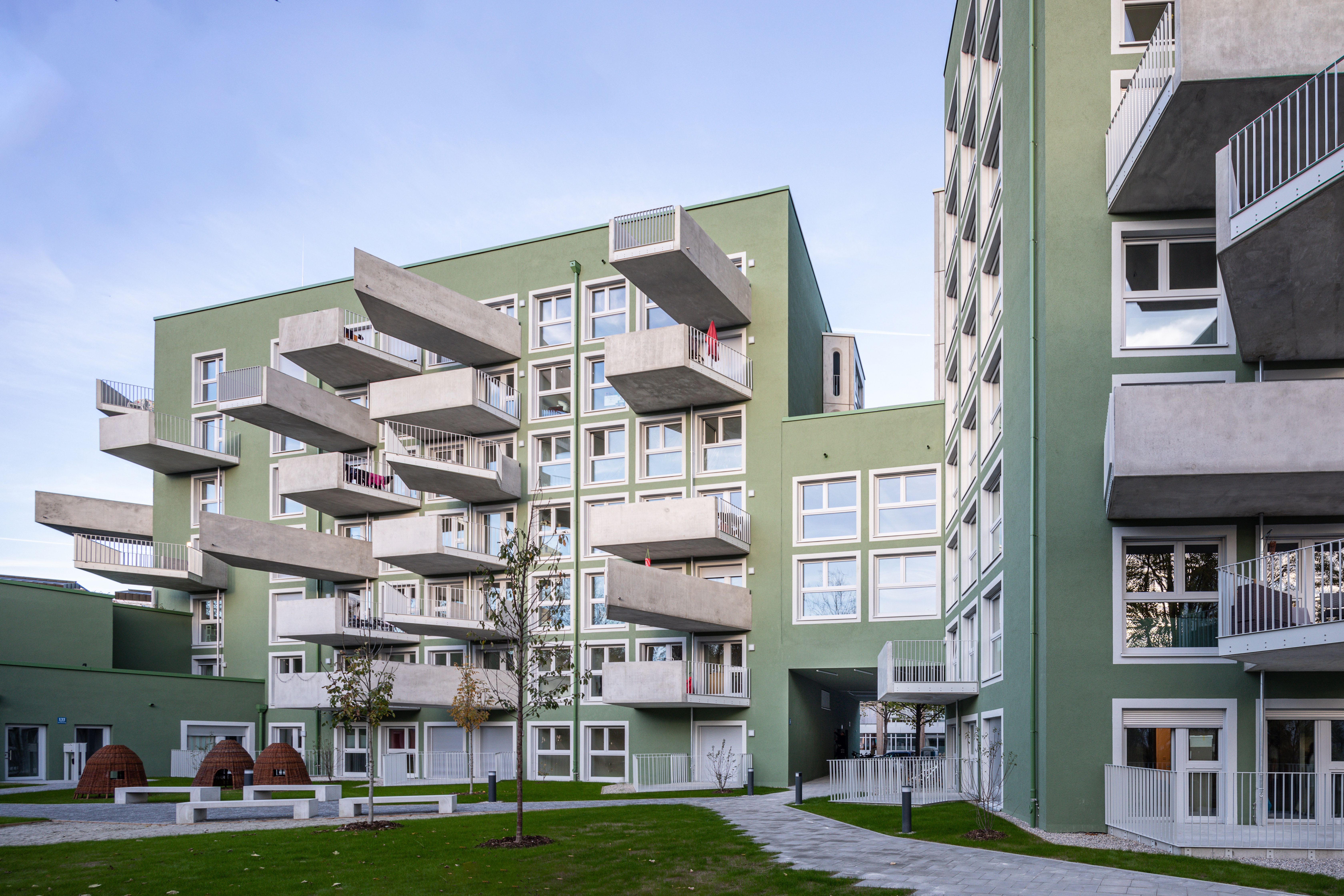 Goetz Castorph Lehmann Tabillion Architektur Städtebau München grün Balkone Raute Karo auskragend Dachterrase Mehrfamilienhaus Neubau Wohnen Nacht Perlach Neuperlach Gustav Heinemann