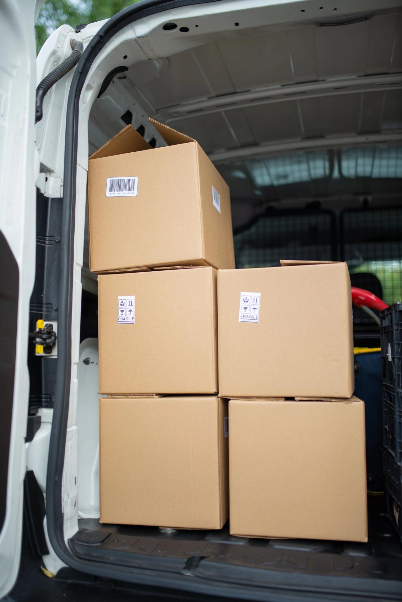 Stacked cardboard boxes in the back of an open van.