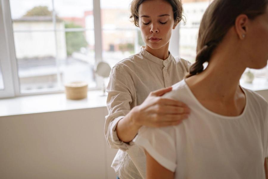 Physical therapist assessing a patient’s shoulder during a first visit
