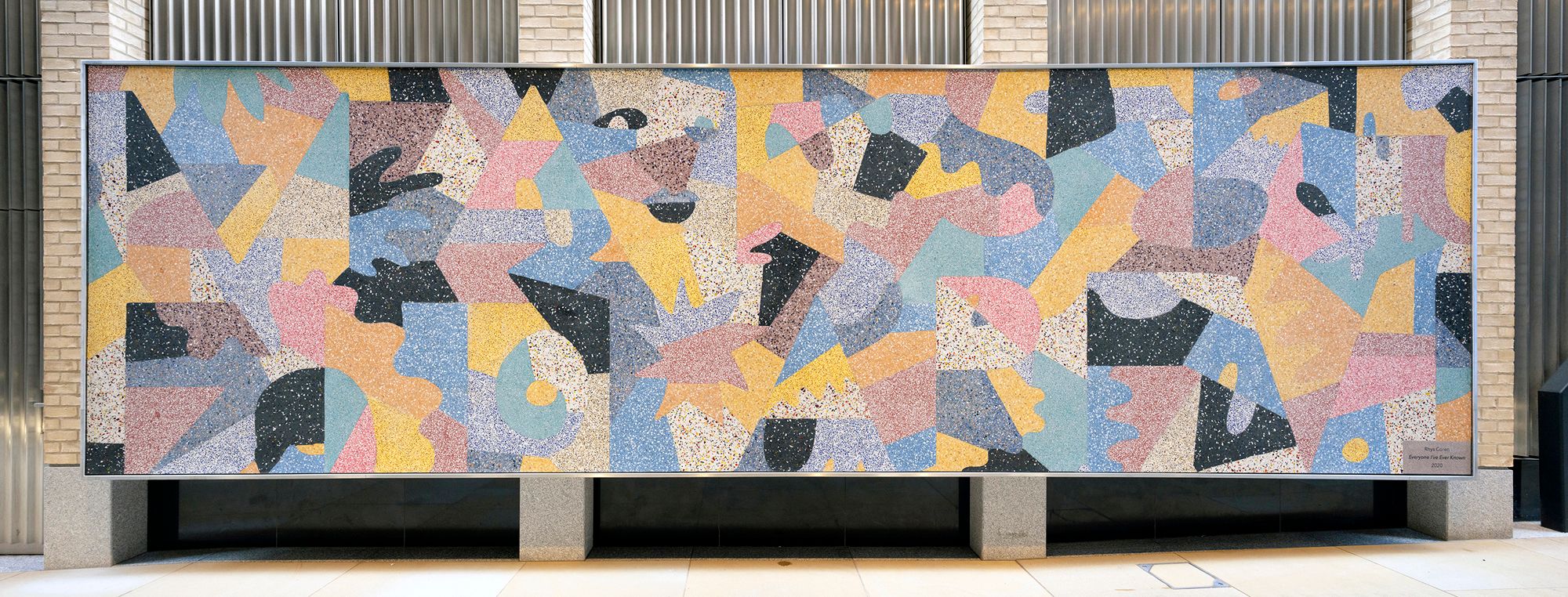 Colorful abstract mosaic mural with speckled, irregular shapes.
