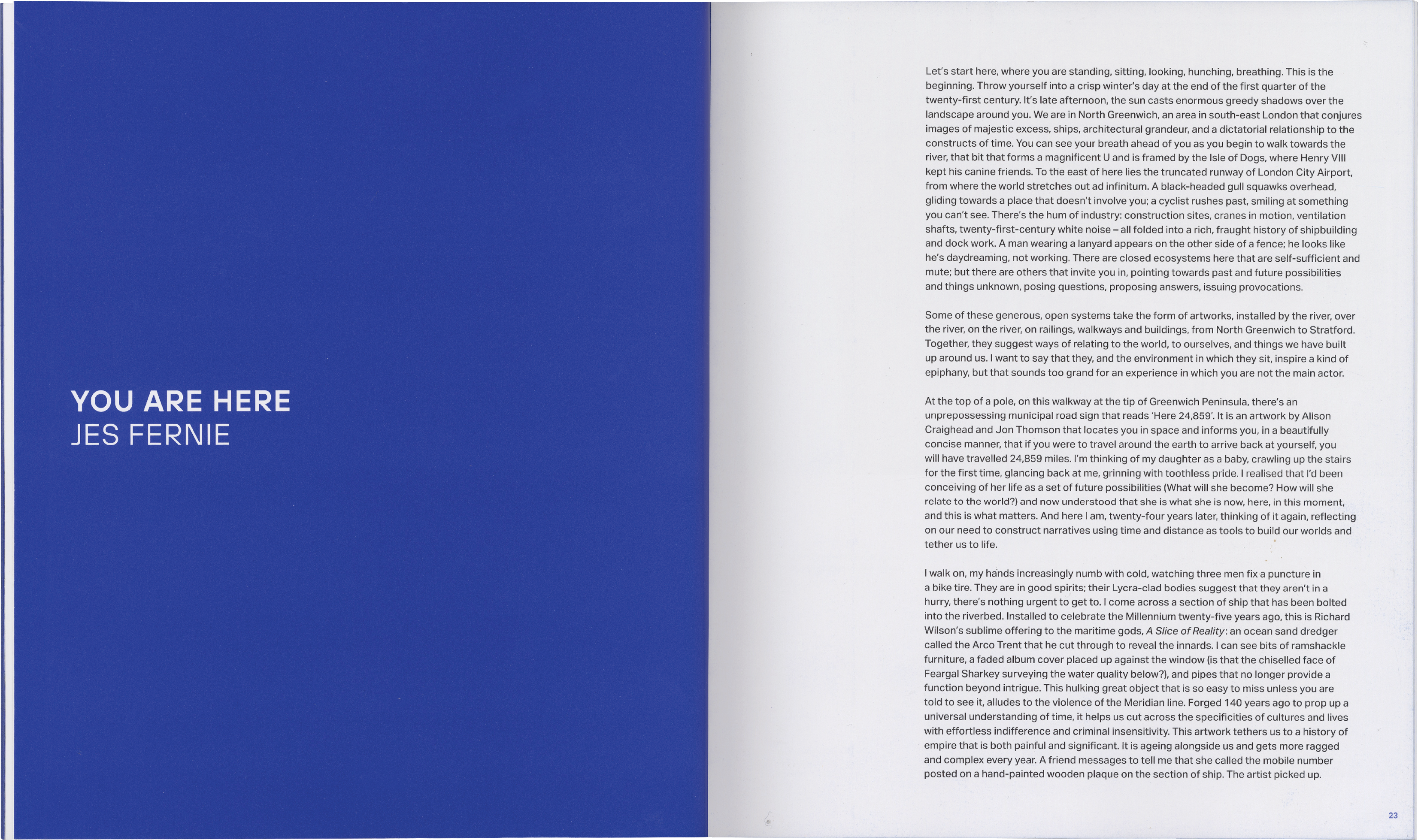 An open book. The left page is solid blue with white text "YOU ARE HERE" by "JES FERNIE". The right page is white with multiple paragraphs of black text.
