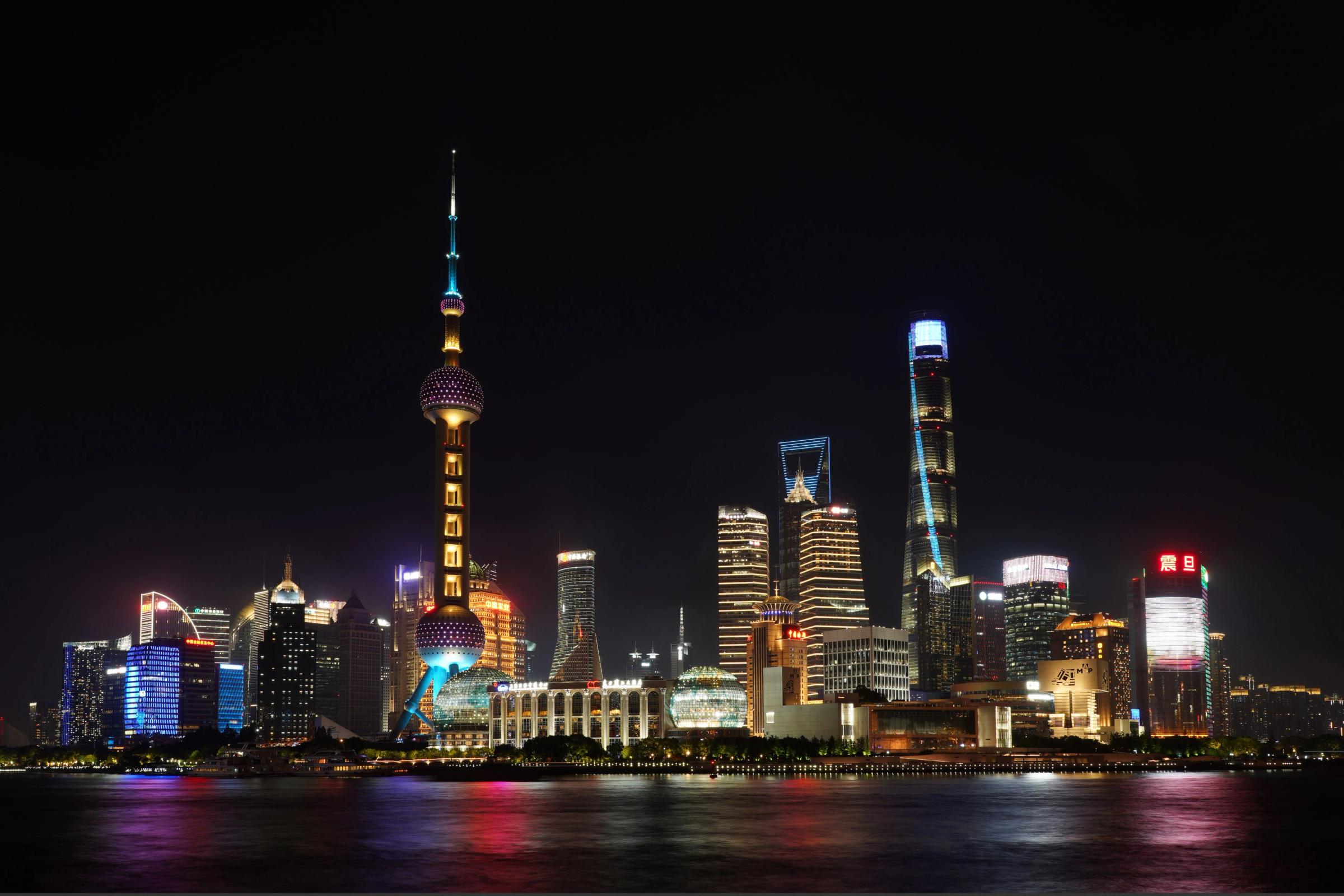 Skyline Pudong Shanghai menyala di malam hari dengan Oriental Pearl Tower dan Sungai Huangpu