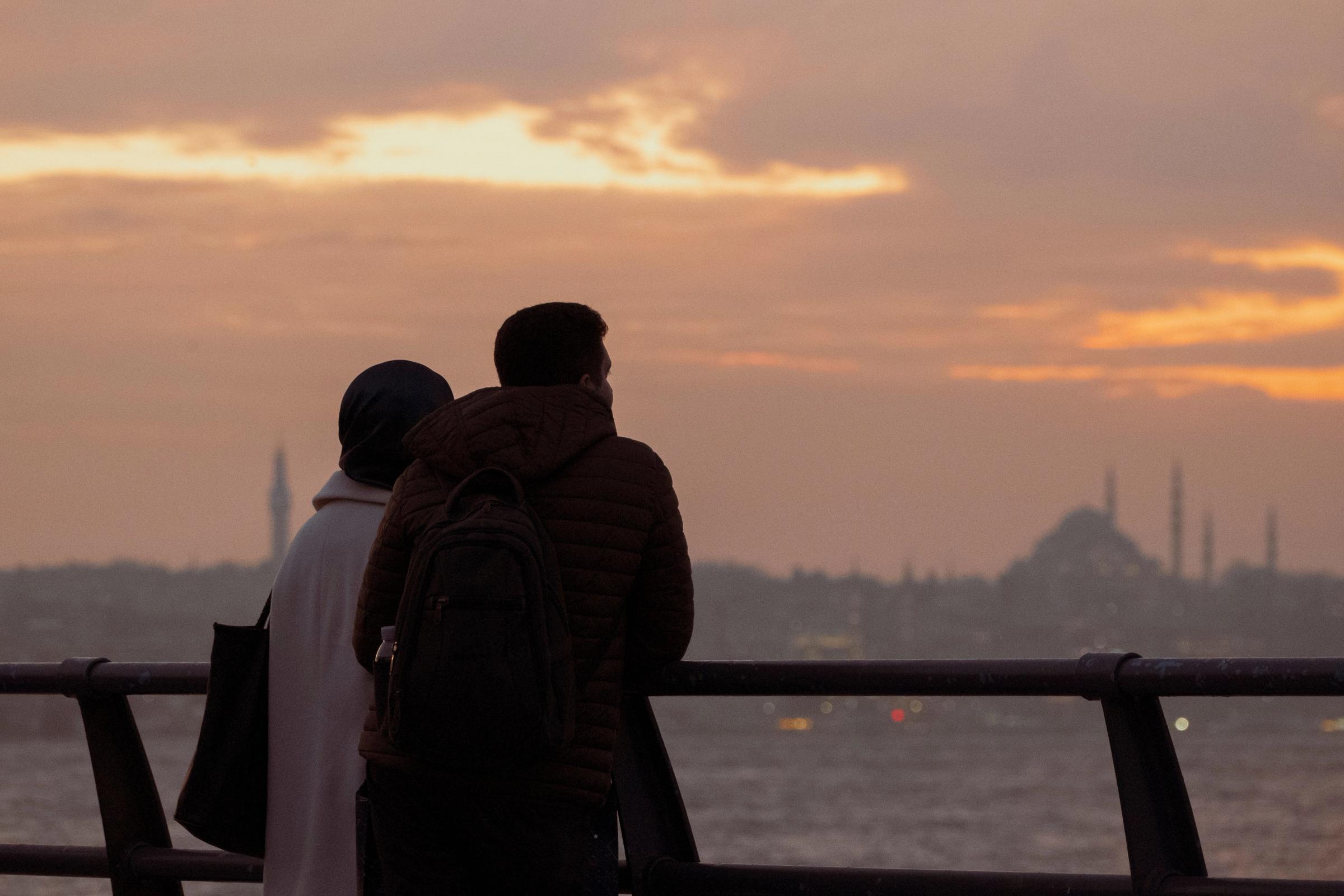 Pasangan siluet menghadap Bosphorus Istanbul saat senja keemasan