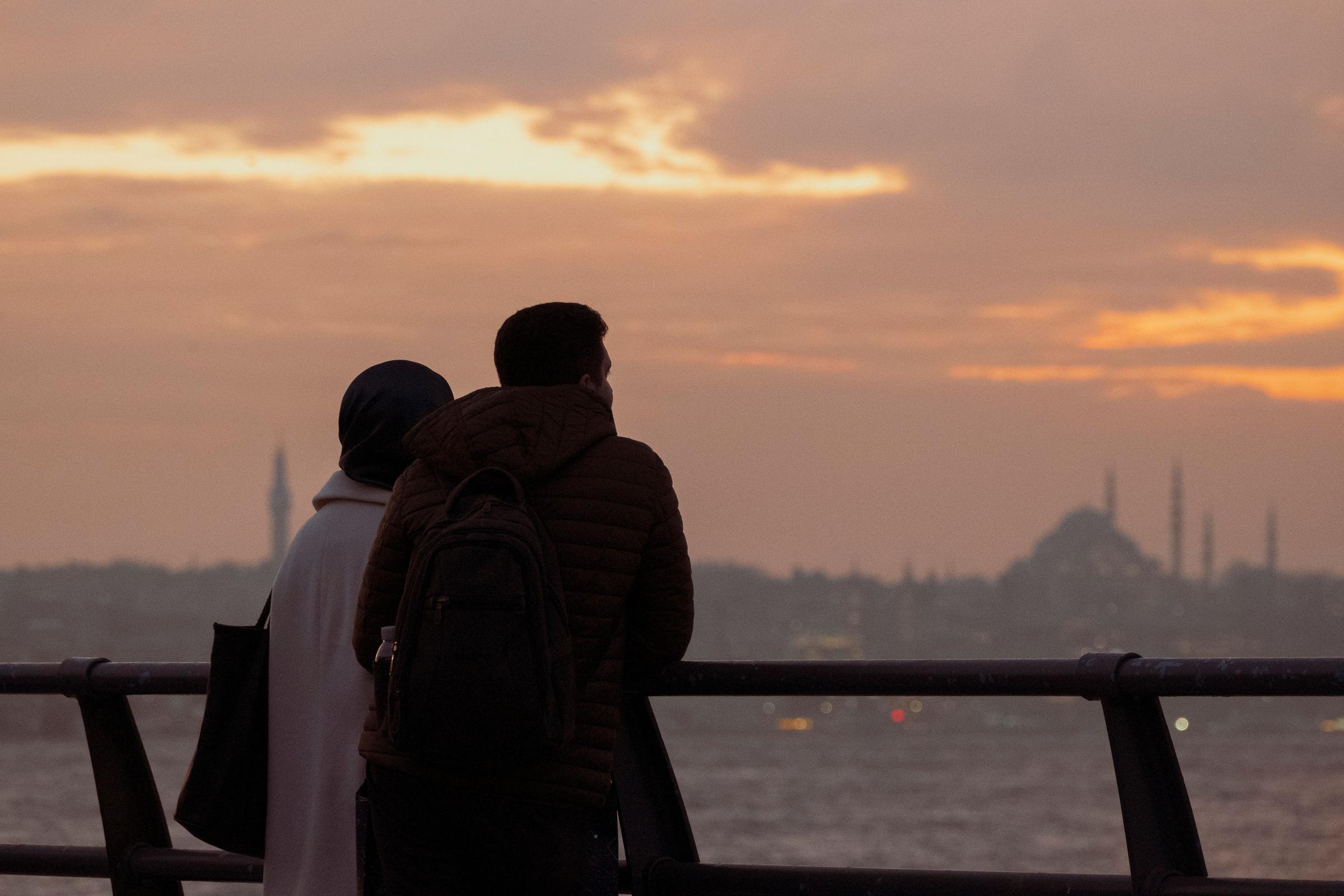 Pasangan siluet menghadap Bosphorus Istanbul saat senja keemasan