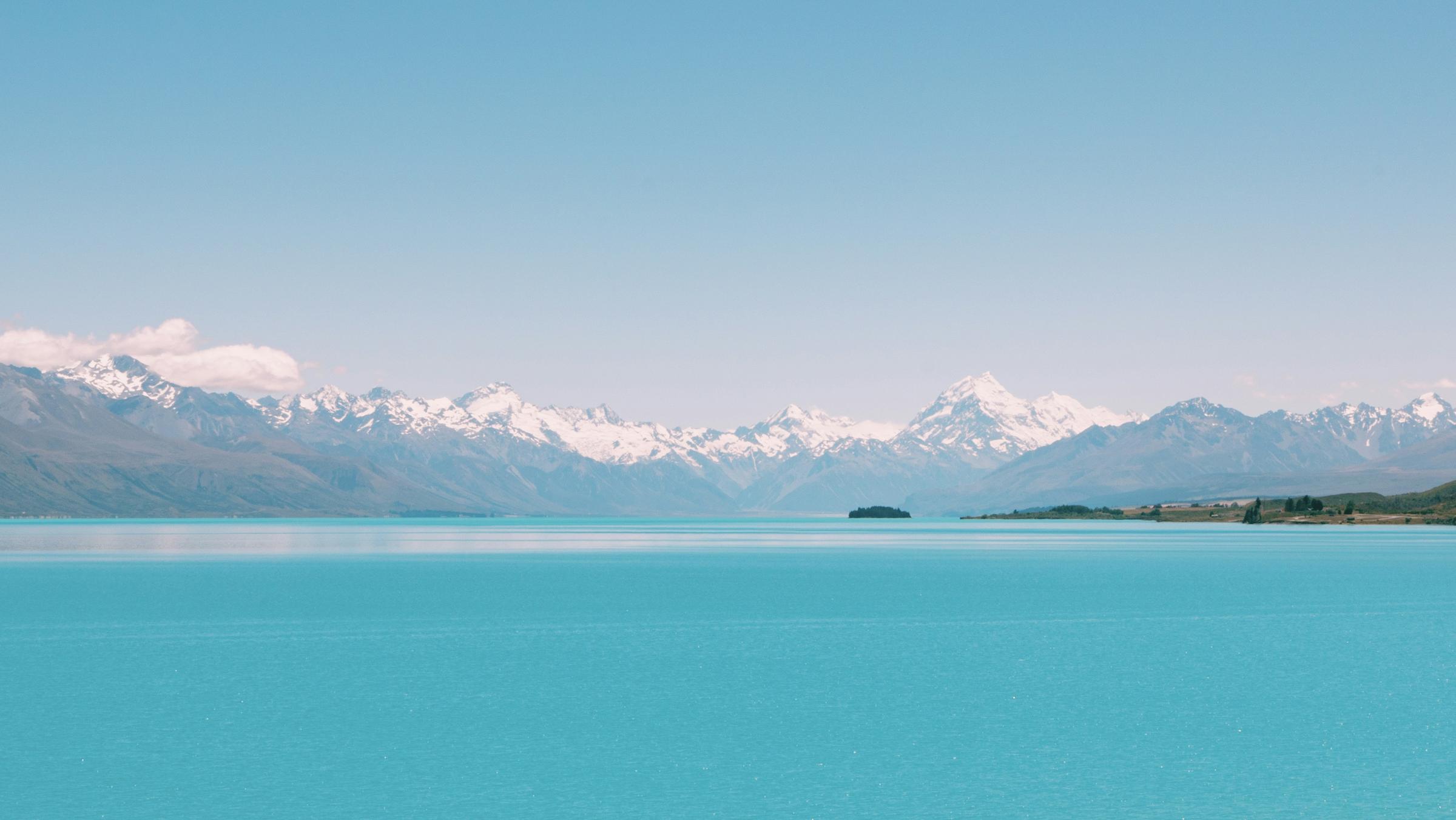 Danau Pukaki berwarna toska dengan Aoraki/Mount Cook bersalju di kejauhan.
