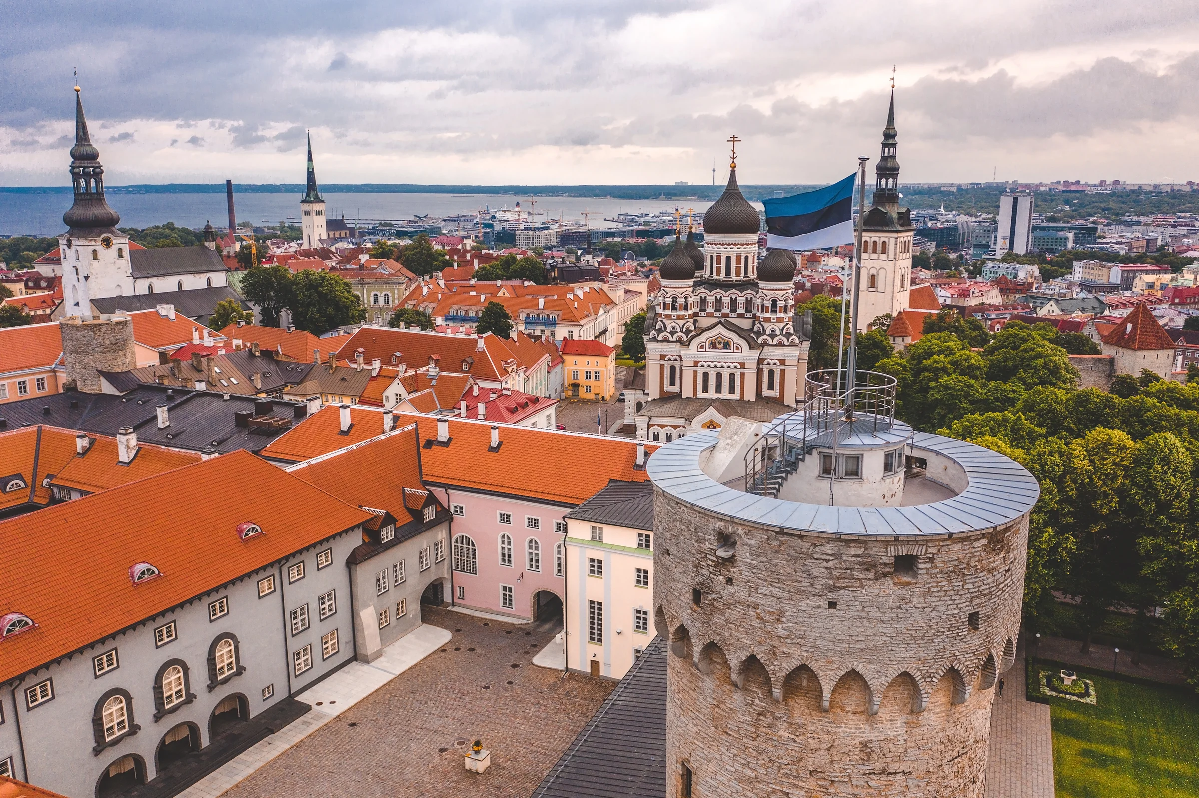 Panorama kota tua Tallinn dari ketinggian dengan menara benteng dan Laut Baltik di kejauhan