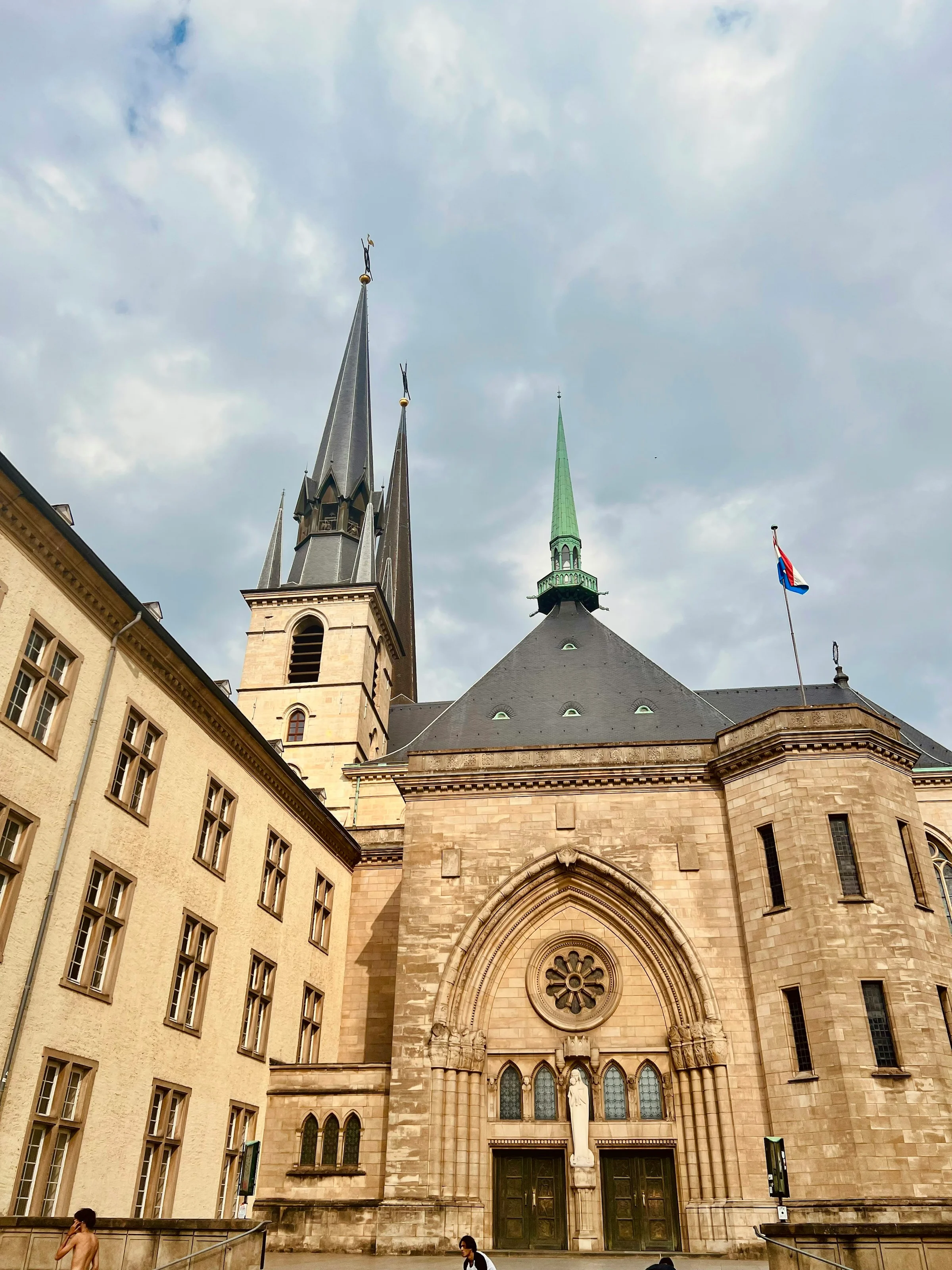 Sisi Katedral Notre-Dame Luxembourg dengan langit berawan kebiruan.