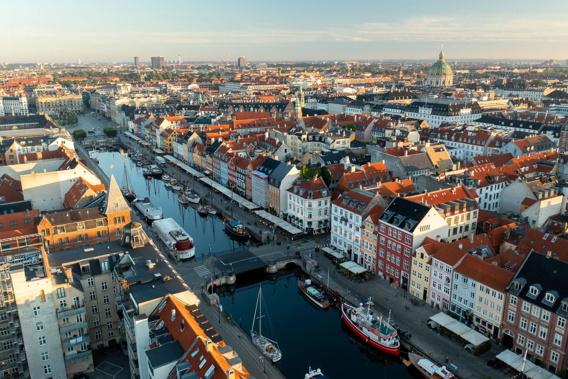 Deretan bangunan warna-warni tepi kanal Nyhavn dilihat dari udara dengan atap merah Copenhagen
