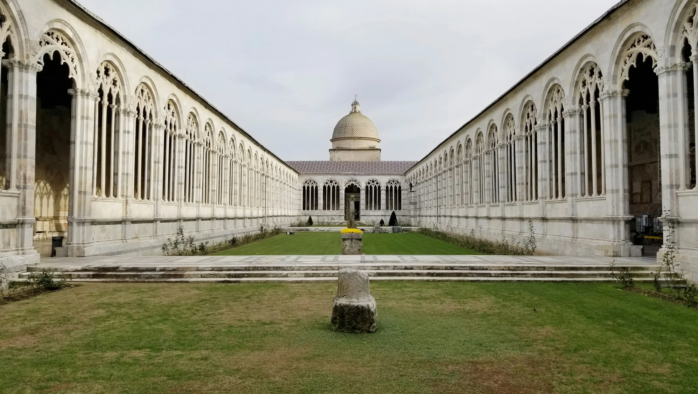 Pemakaman Camposanto di Piazza dei Miracoli Pisa dengan halaman rumput hijau.