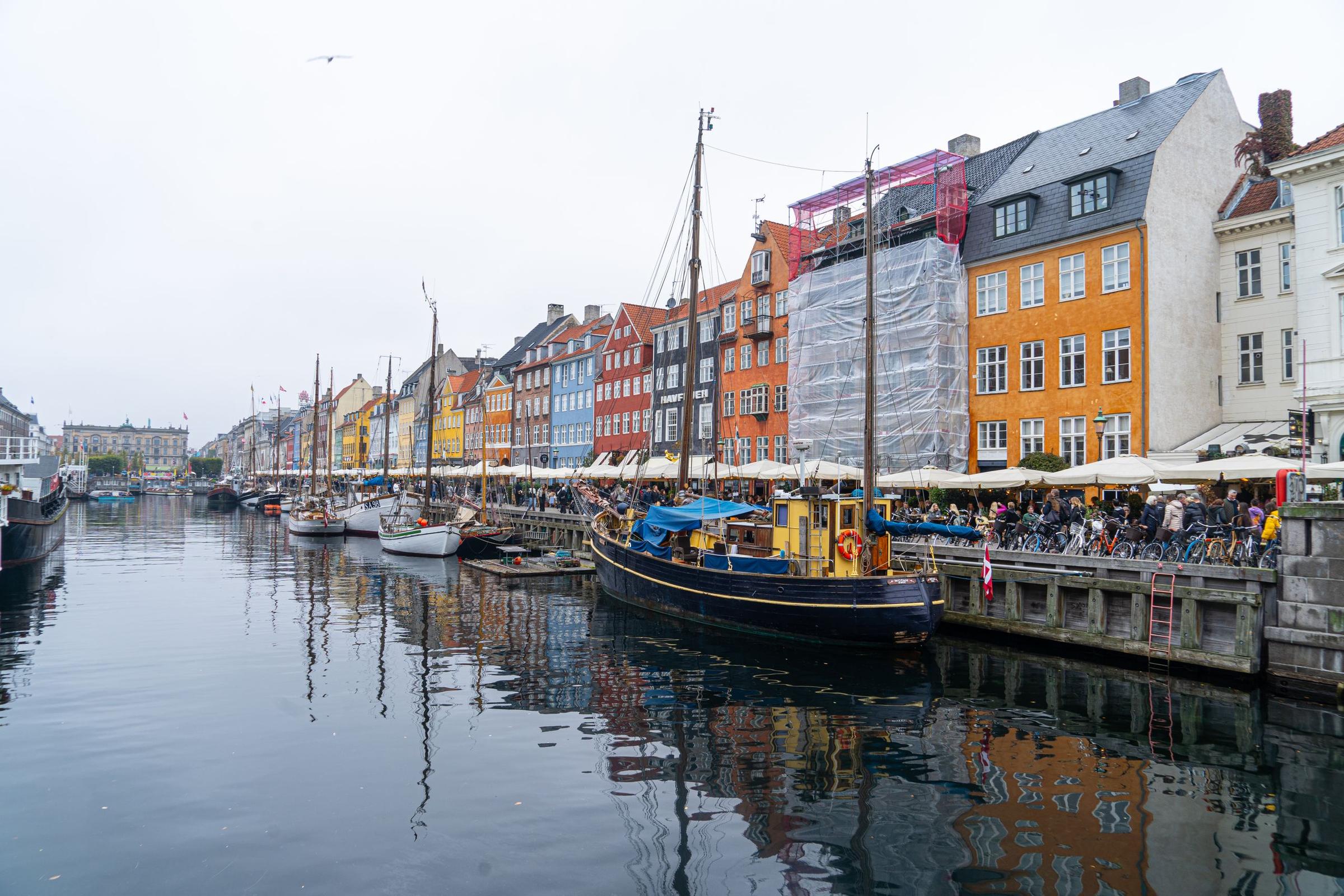Kanal Nyhavn dengan rumah warna-warni dan perahu kayu, Copenhagen.