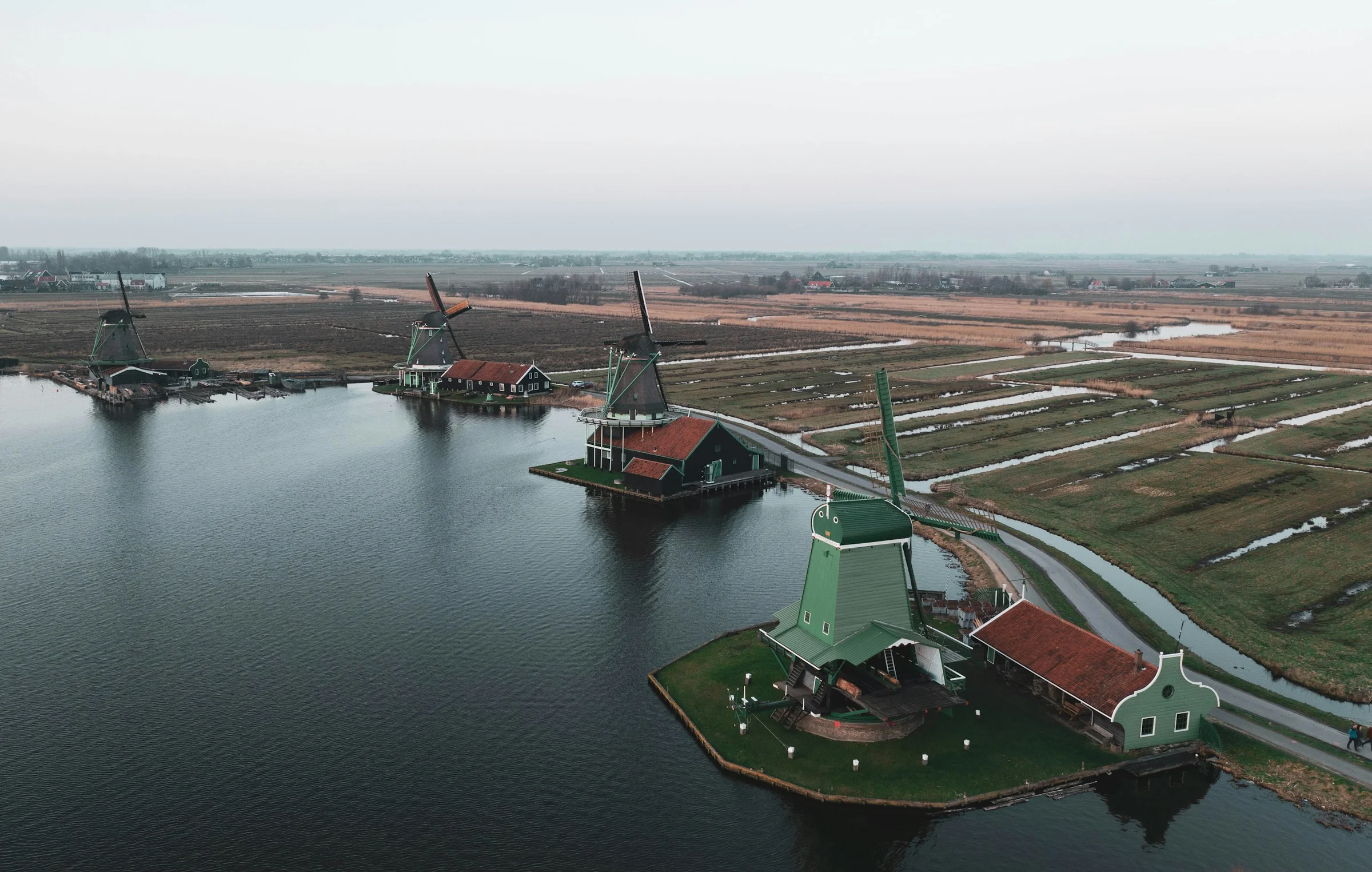 Pandangan udara kincir angin Zaanse Schans di tepi air dan lahan polder, Belanda.