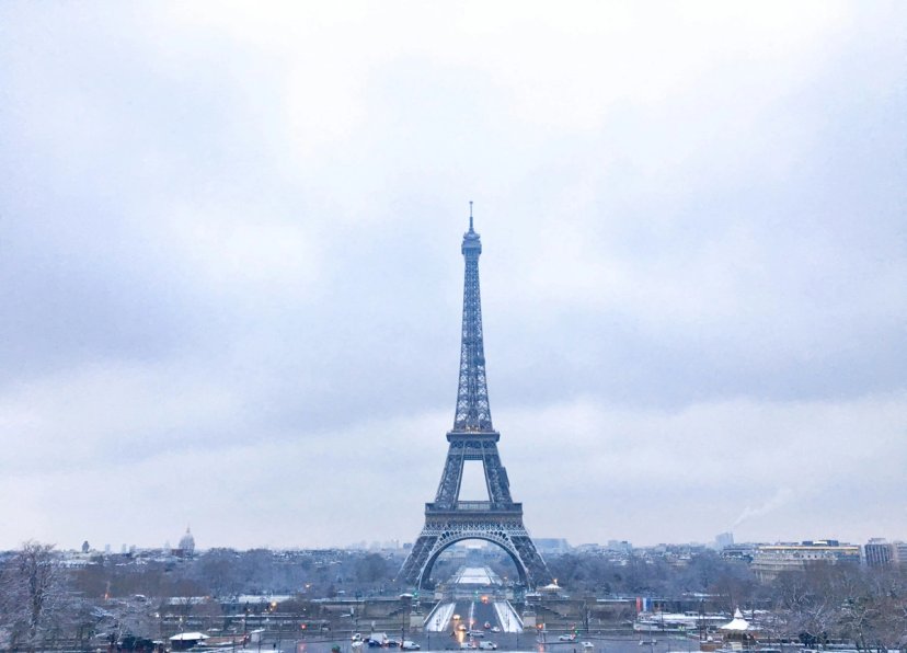 Bangku bersalju di dekat komidi putar Trocadéro dengan Menara Eiffel di kejauhan, Paris musim dingin.