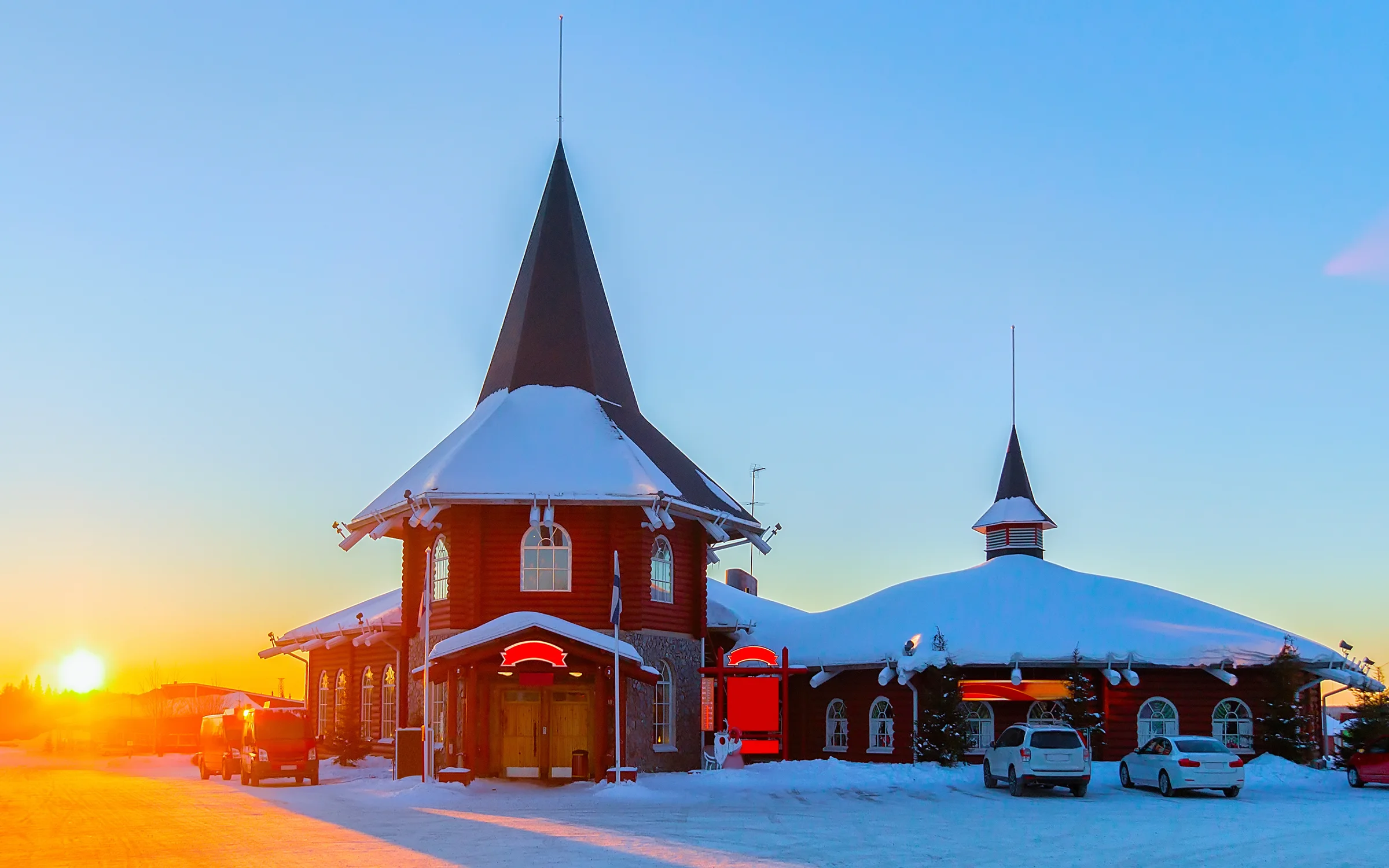 Santa Claus Village di Rovaniemi bersalju saat matahari terbenam keemasan