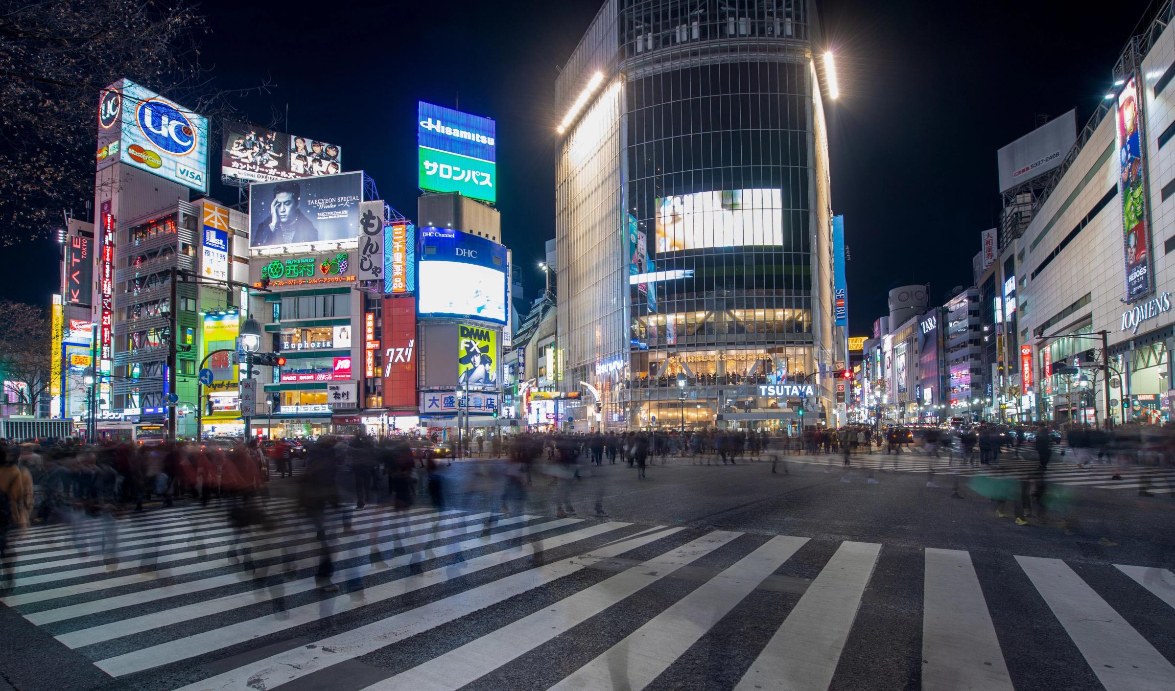 Persimpangan Shibuya Tokyo dipadati pejalan kaki malam hari berlatar lampu neon papan reklame