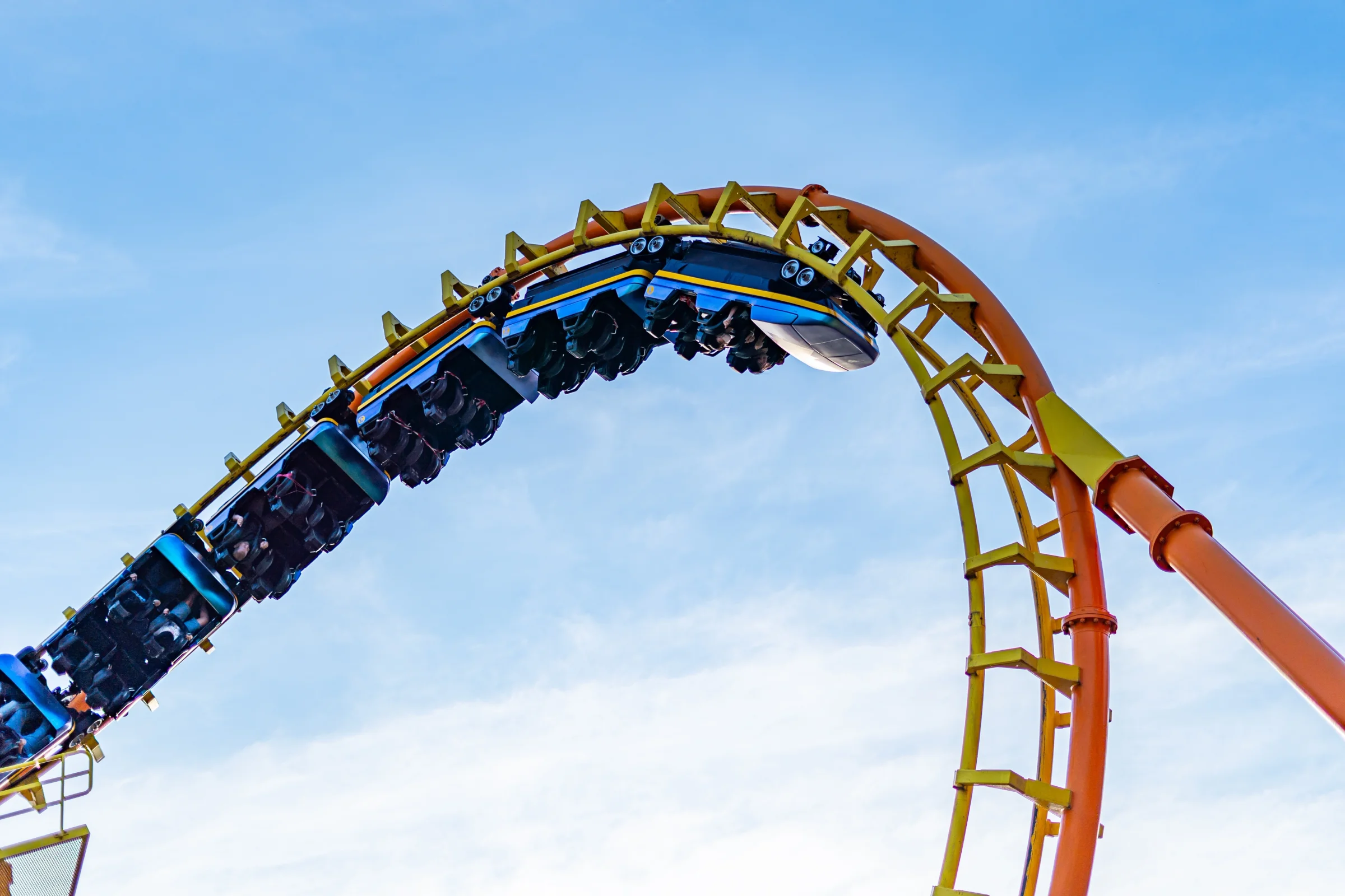 Wahana roller coaster di taman hiburan dengan langit biru