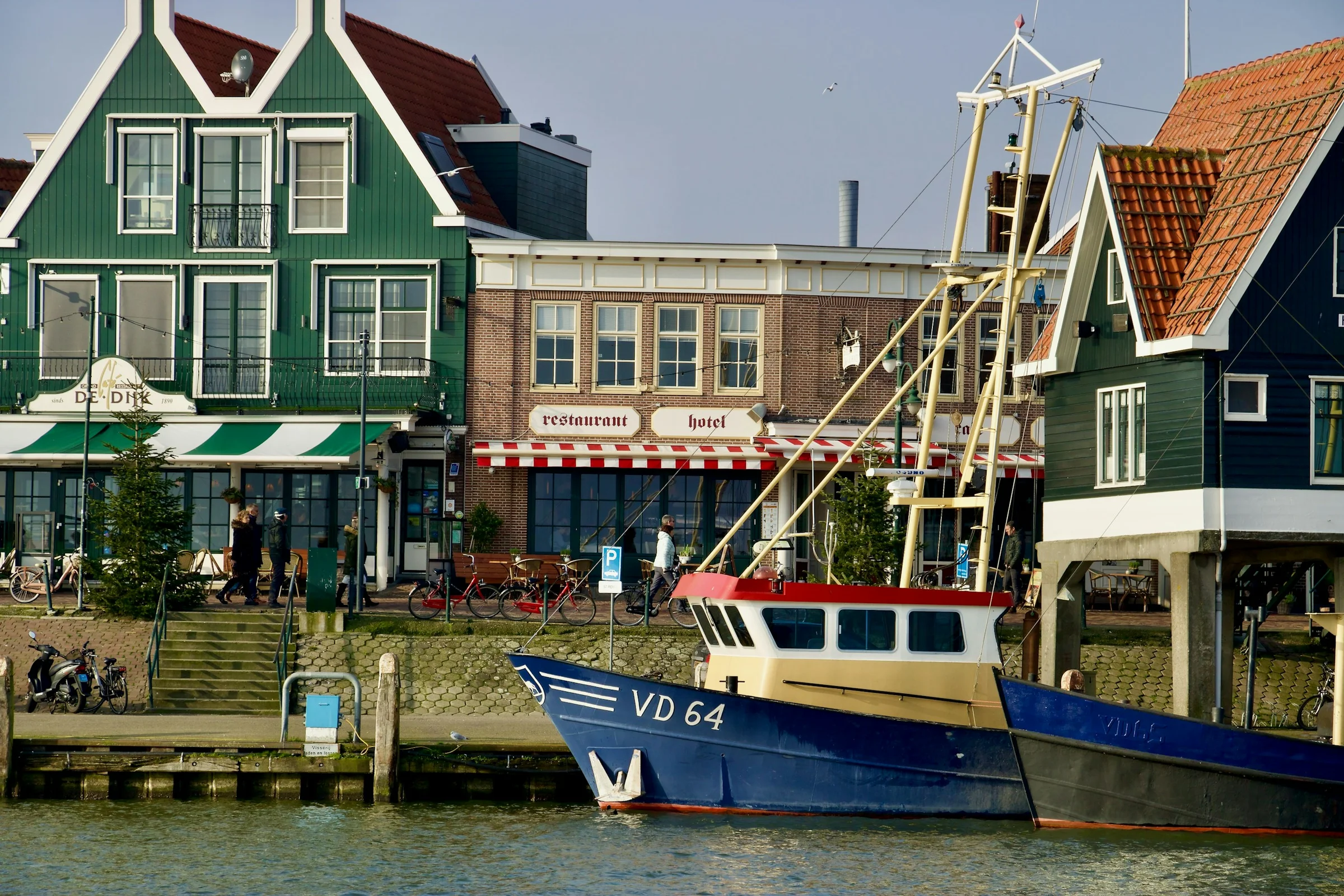 Pelabuhan Volendam dengan rumah kayu hijau dan kapal nelayan, Belanda.