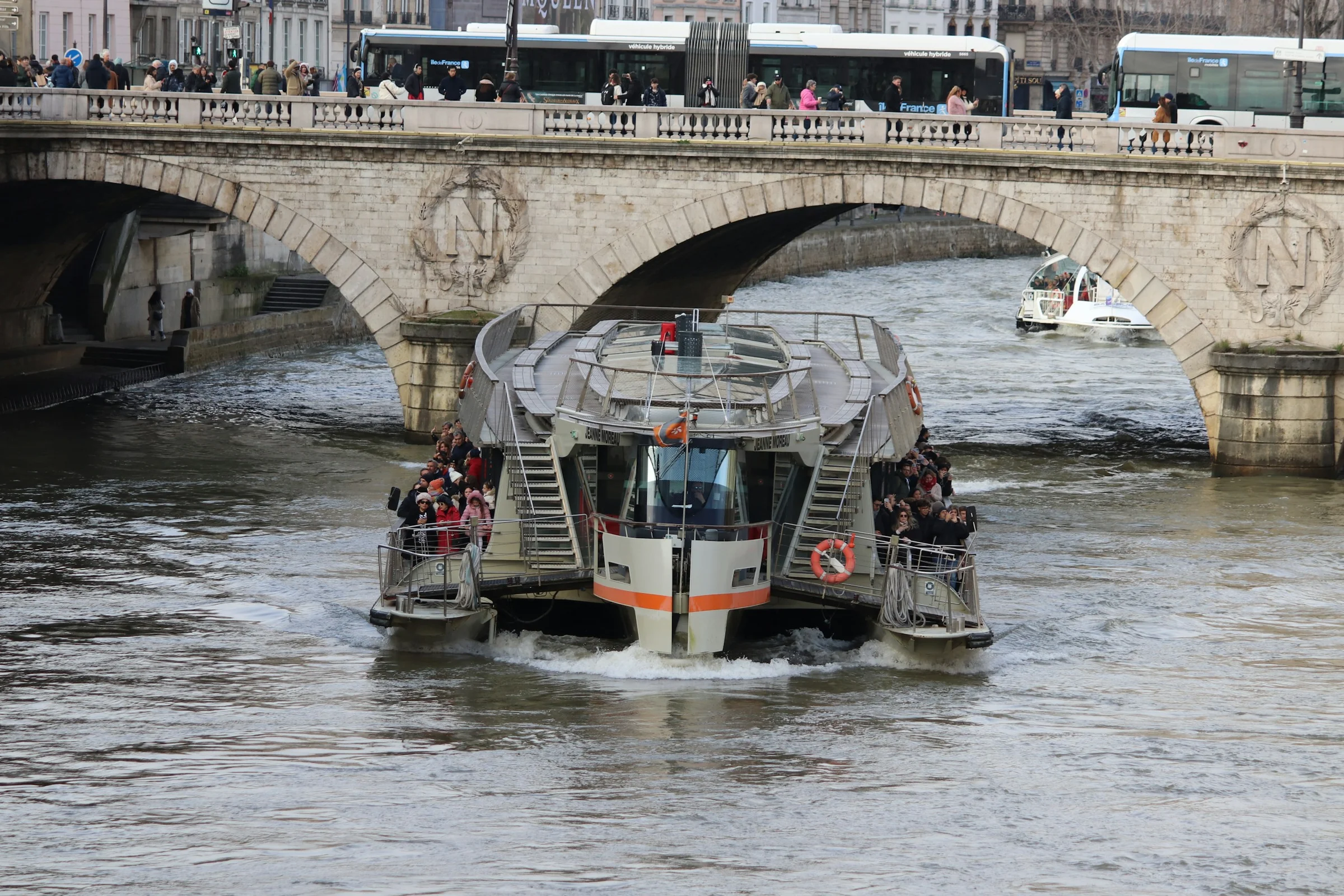 Kapal wisata Sungai Seine melintas di bawah jembatan batu Pont Neuf, Paris.