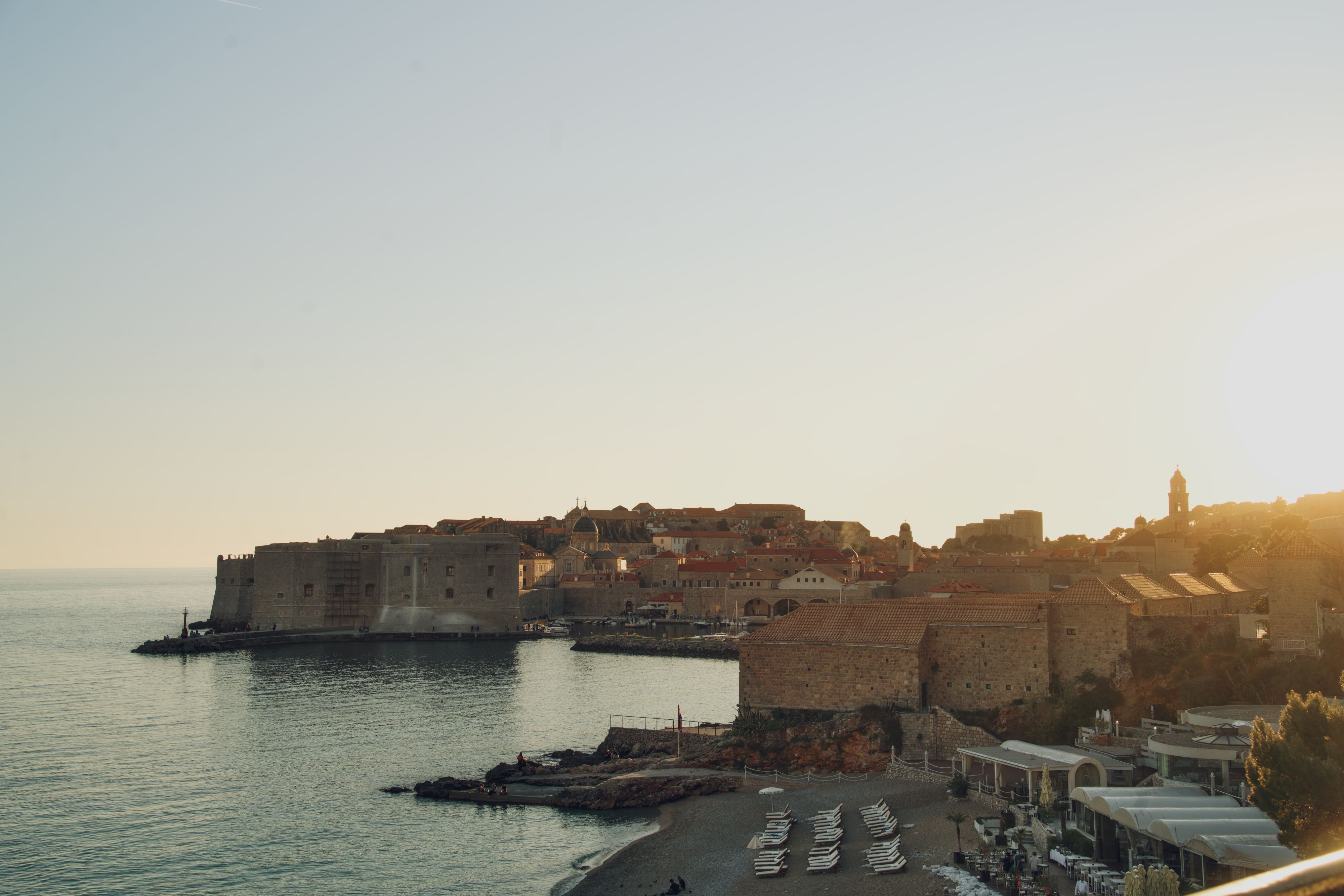 Kota Tua Dubrovnik, Kroasia, saat matahari terbenam dengan pantai di tepi laut