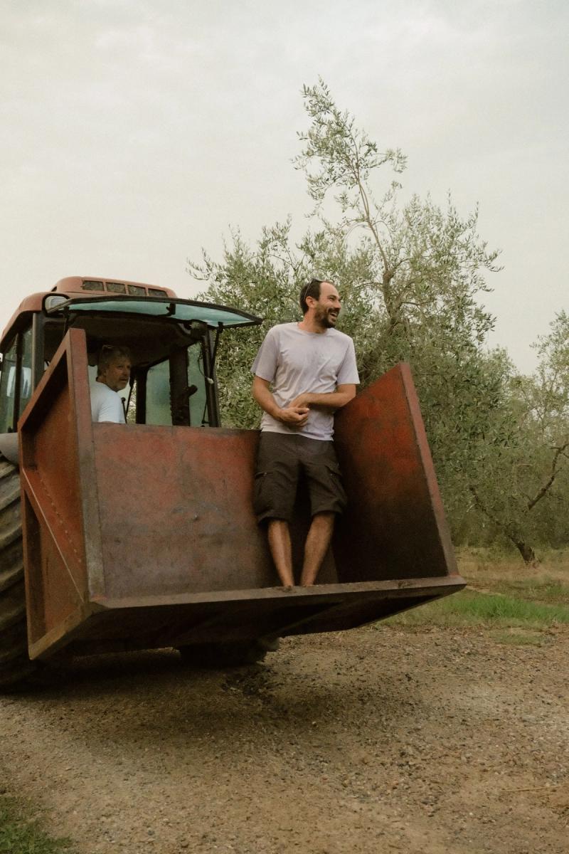 Two of us riding the front loader of a borrowed tractor through the grove