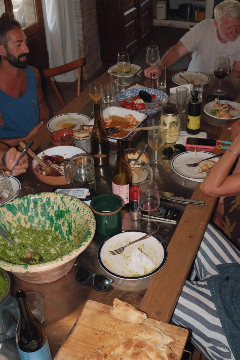 A family-style supper seen from above: prawns, salad, bread and half-empty glasses