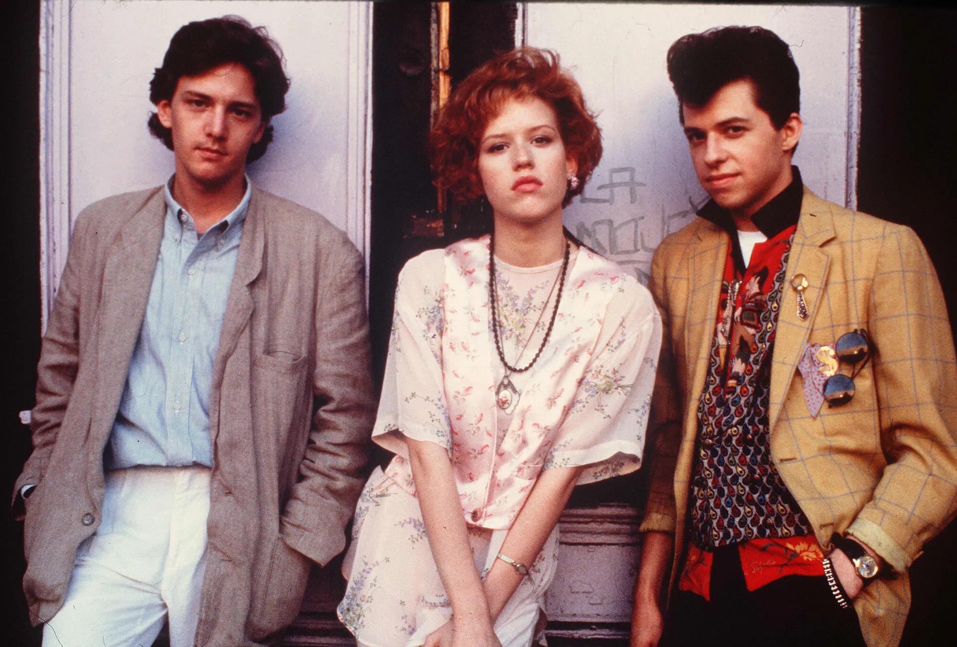 Three friends standing together wearing vintage fashion clothing.
