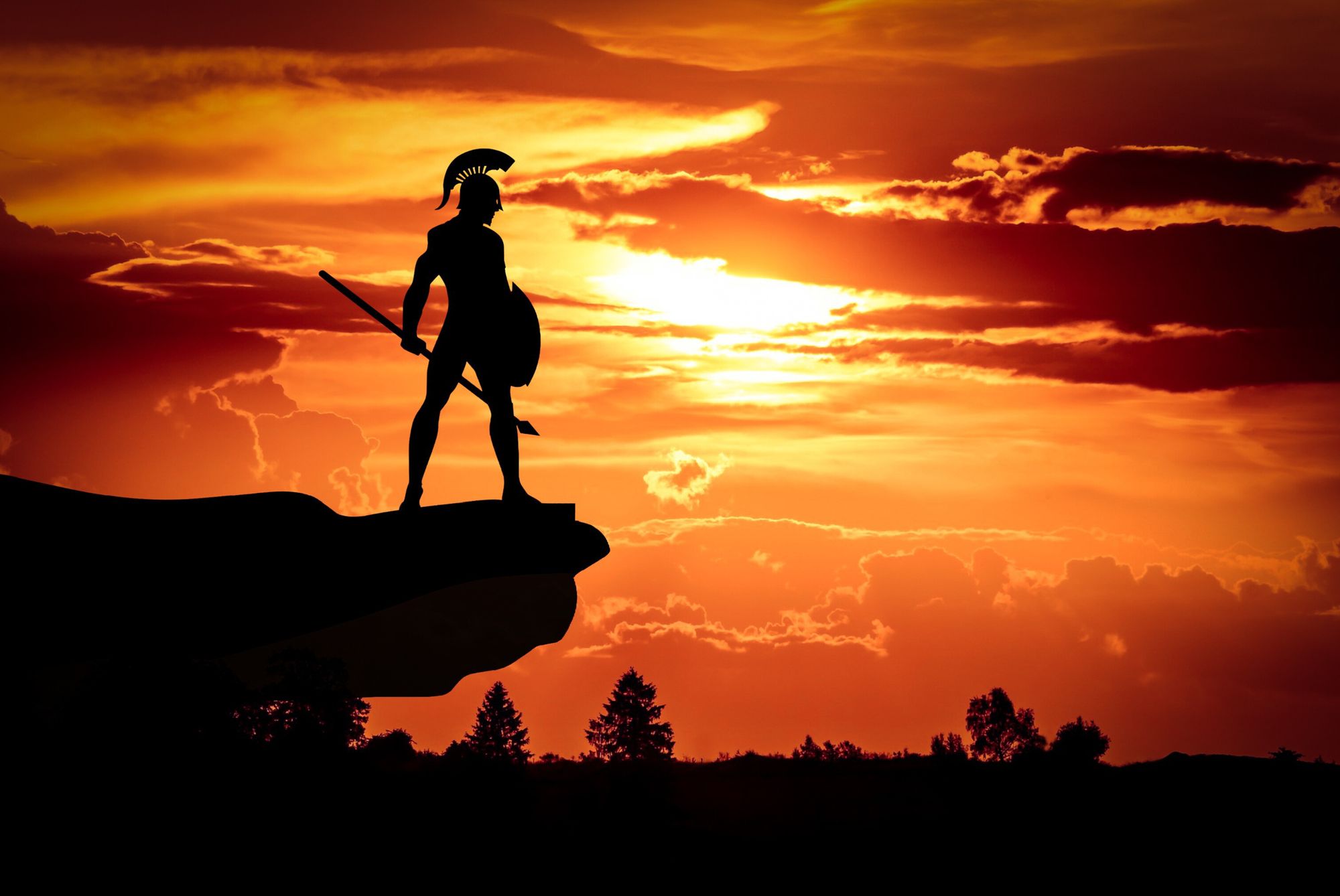 A spartan standing on a cliff rock with a sunset background.