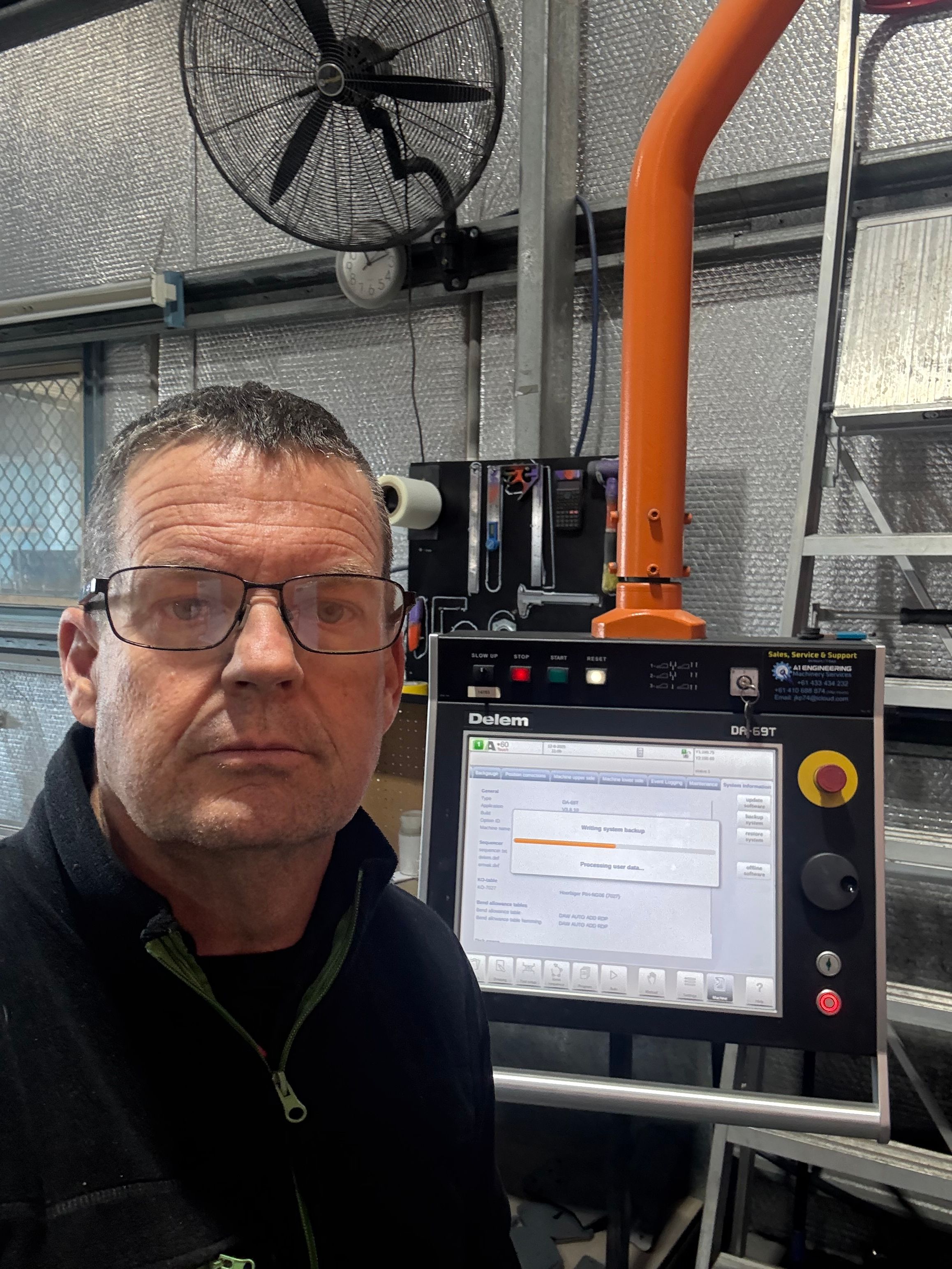 Technician beside a Delem DA-69T press brake control writing a system backup.
