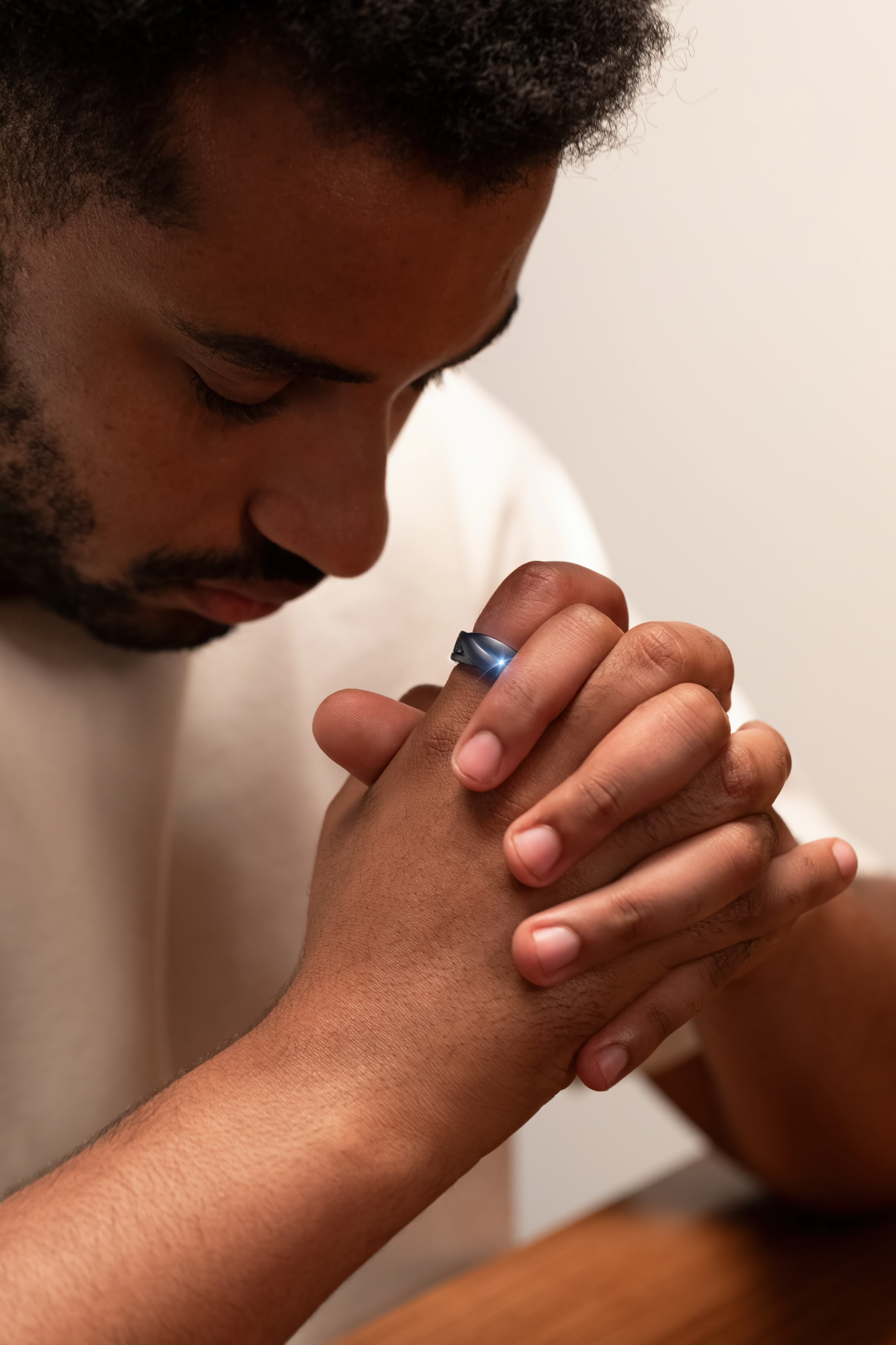 A man praying while wearing Glorify Ring