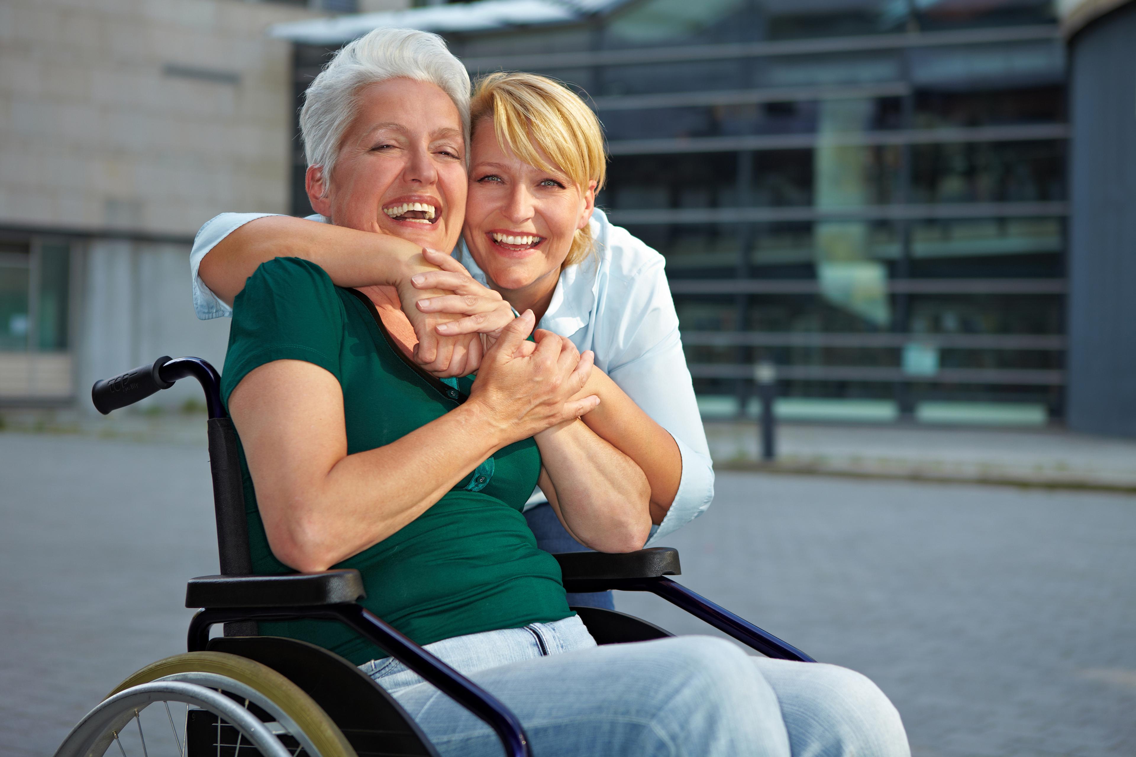 Helsefagarbeider klemmer dame i rullestol