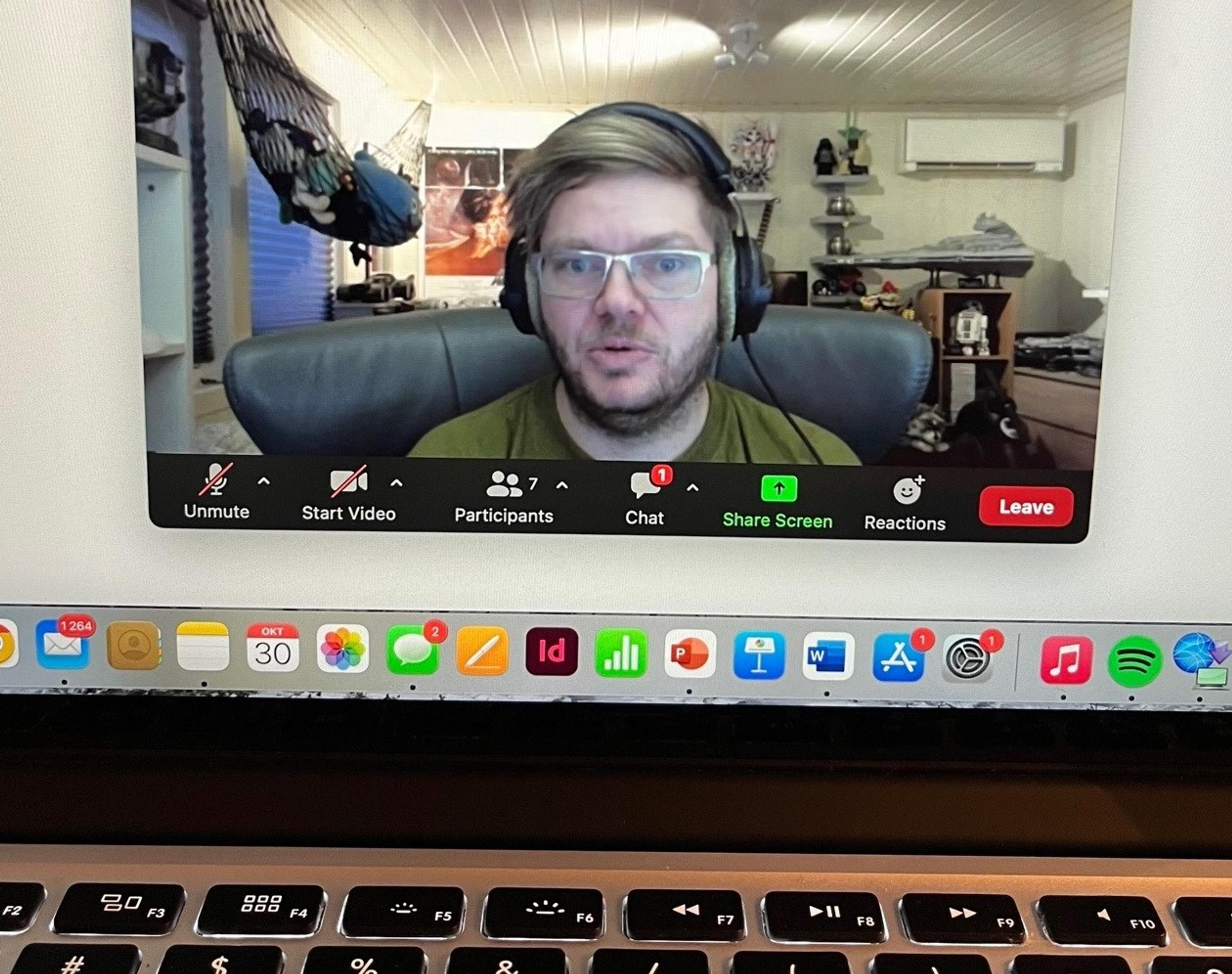 Lærer med headset sees på en PC-skjerm i forbindelse med zoom-undervisning.