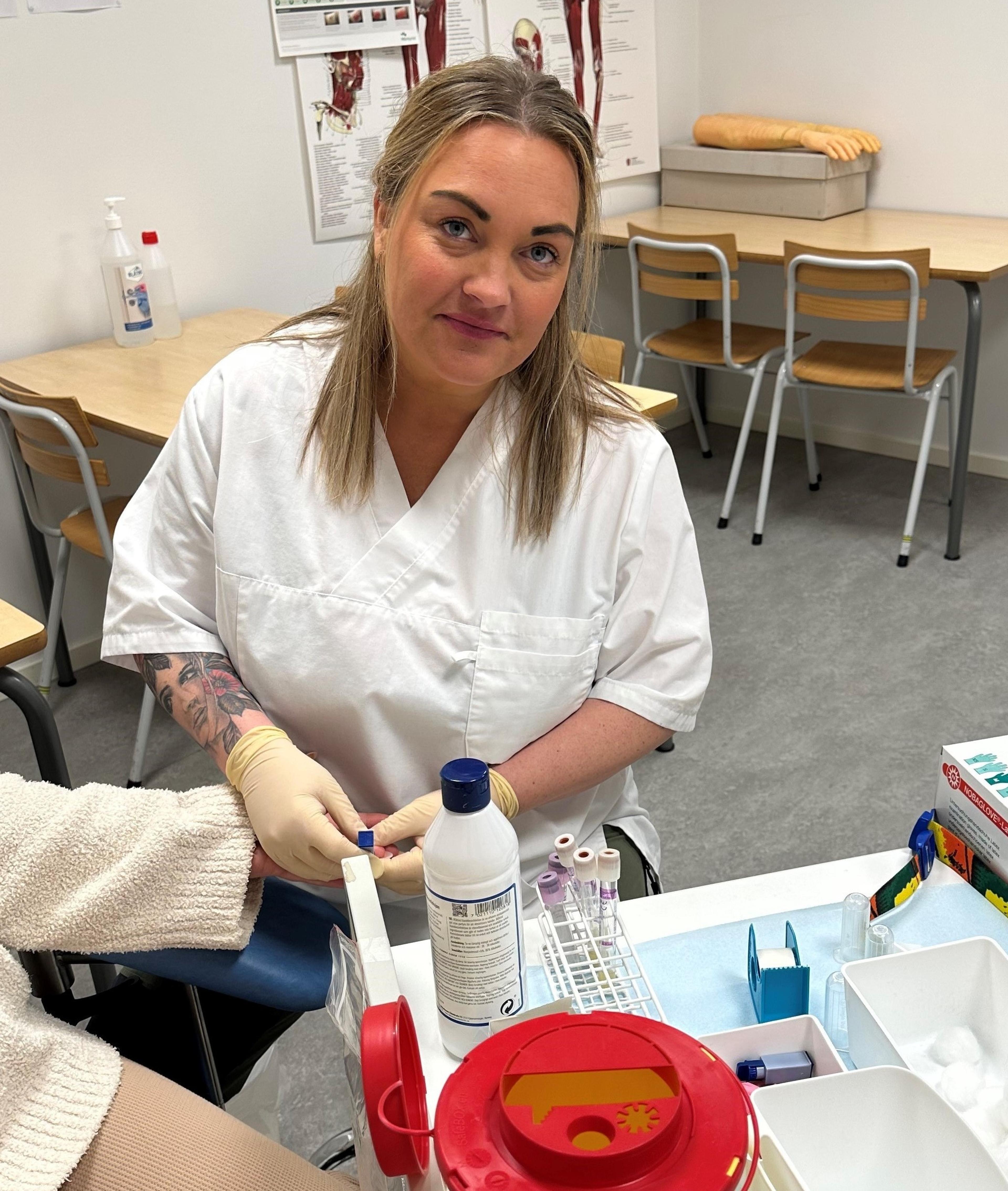 Student ved Helsesekretærutdanningen ved Folkeuniversitetet øver på å ta blodprøve på øveøseslaboratorium.