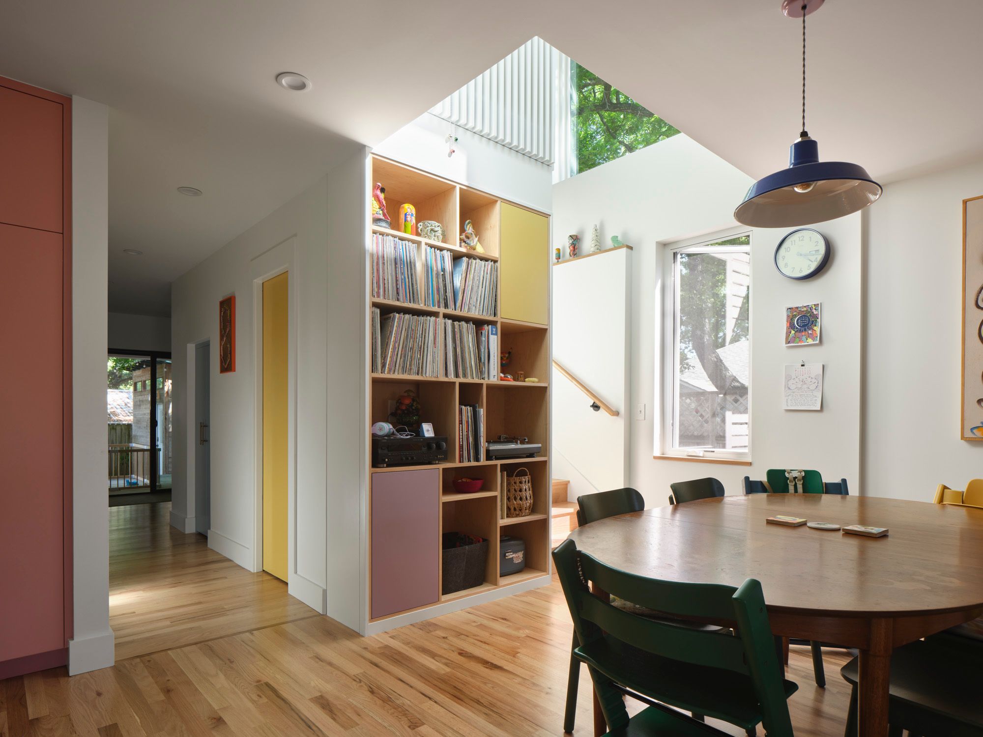Dining area with round table, record shelving and overhead skylight