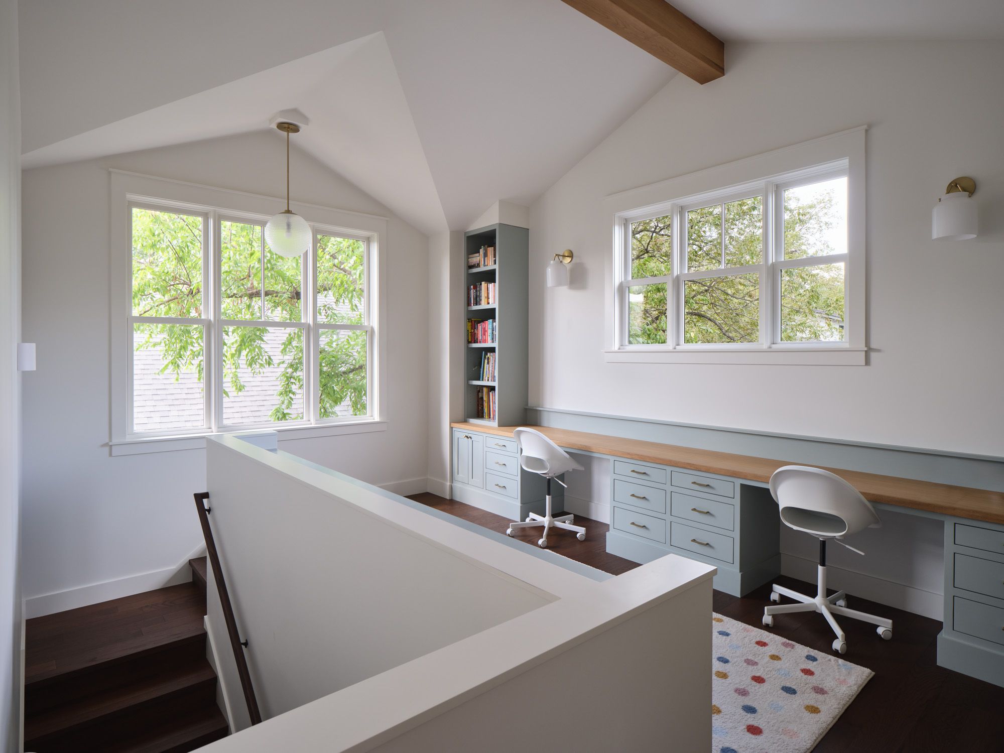 Home office with two workstations, built-in desks and large windows