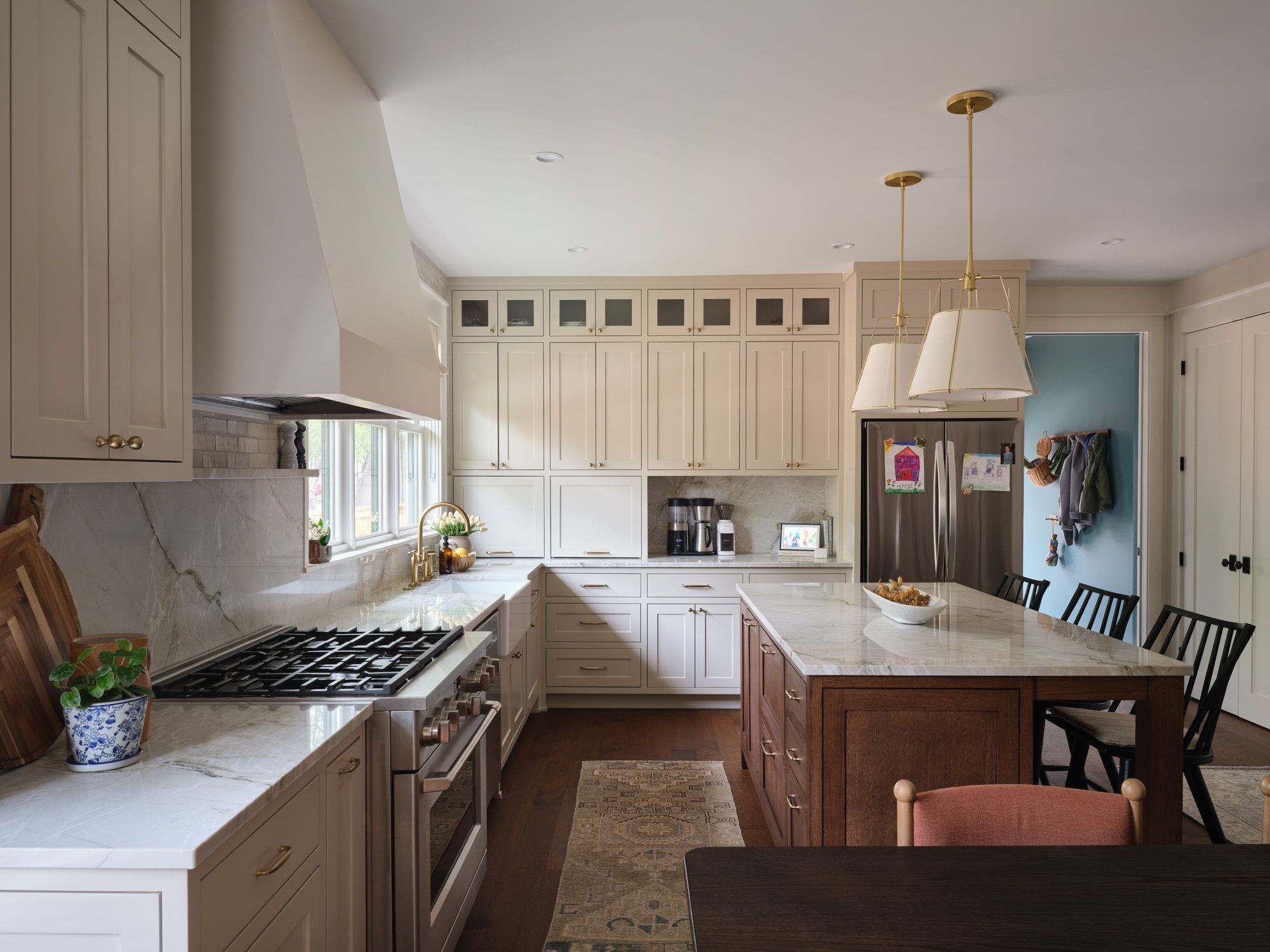 Kitchen with marble counters, central island, pendant lights and bar seating