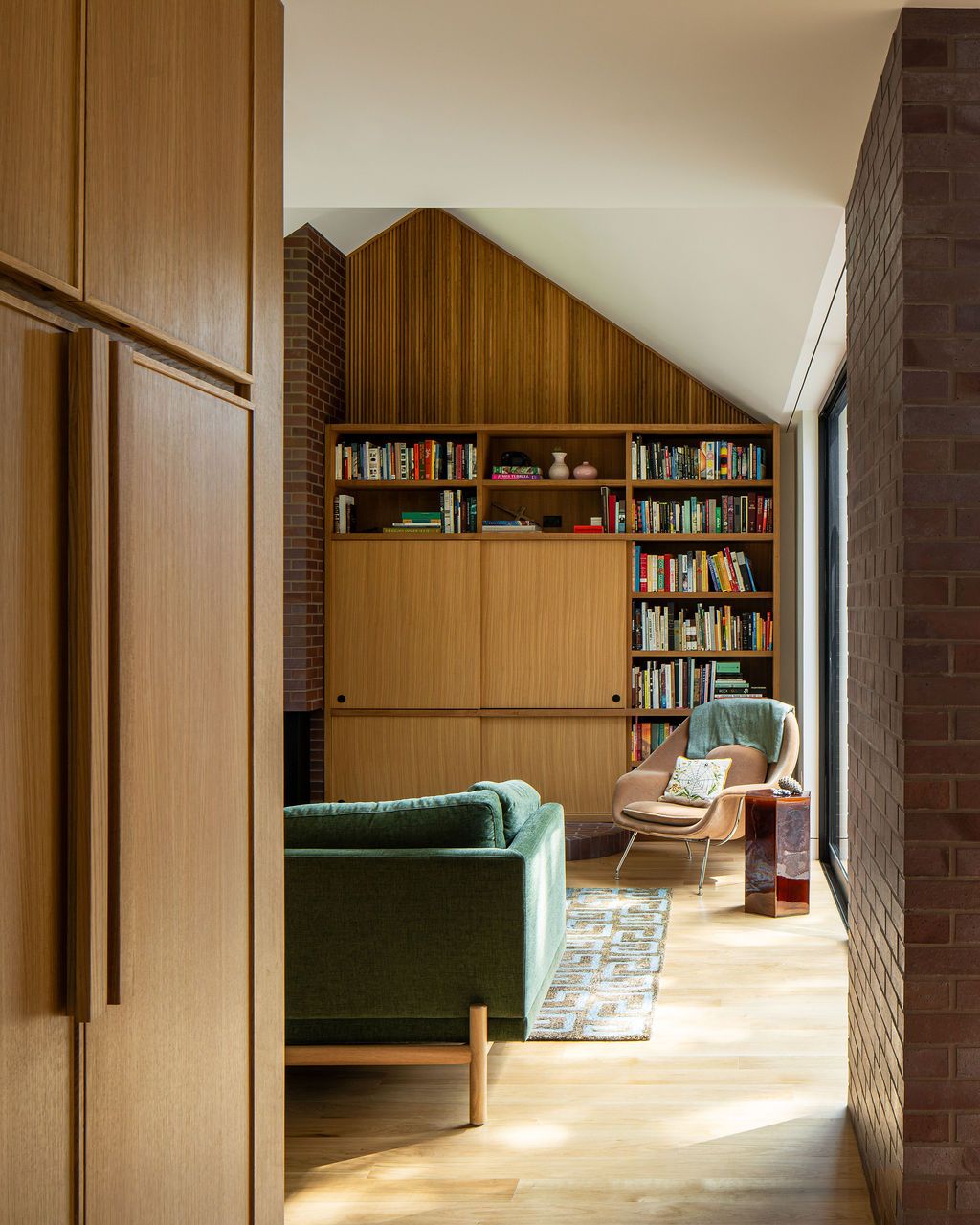 Living room with built-in bookshelves, green sofa and lounge chair
