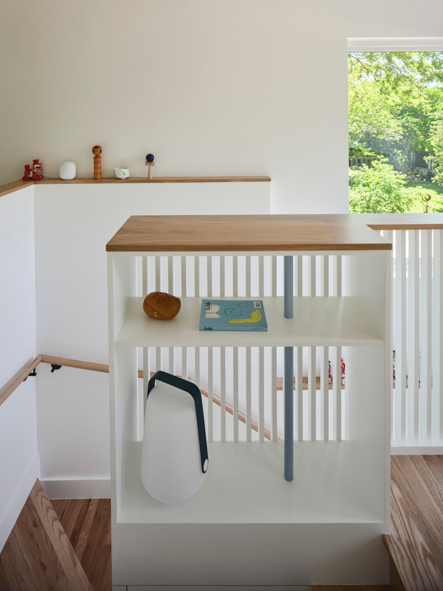 Built-in shelving and wood countertop beside a stairwell window
