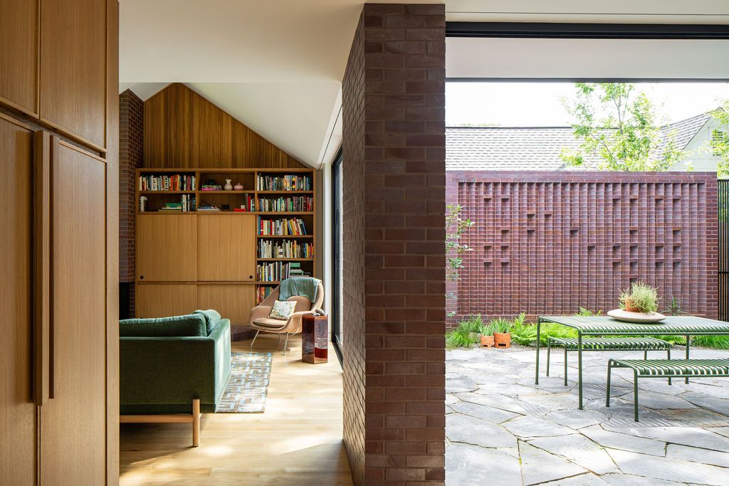 Living room opens onto a brick-walled courtyard with outdoor dining table