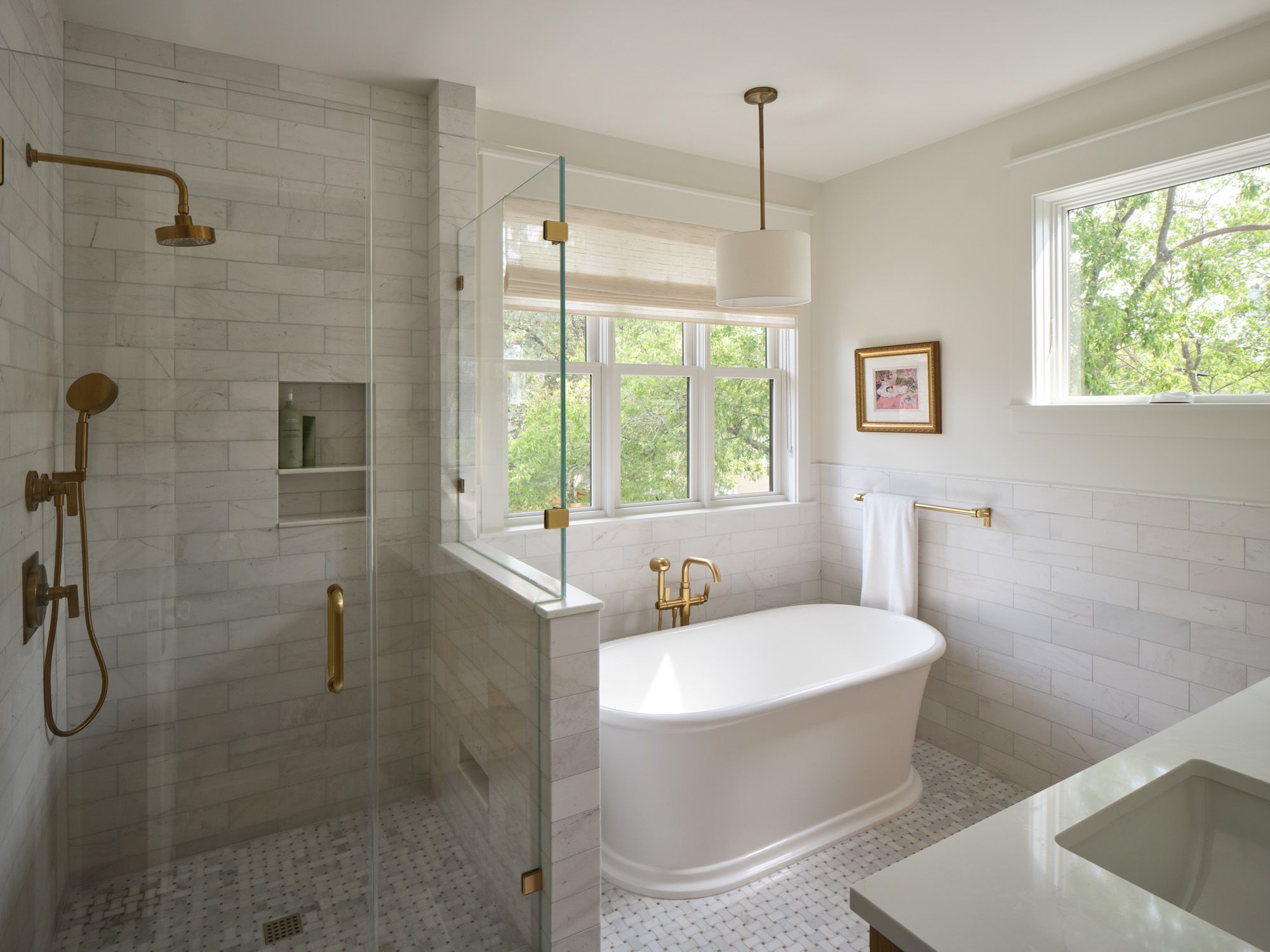 Bathroom with glass-enclosed shower, freestanding bathtub and brass fixtures
