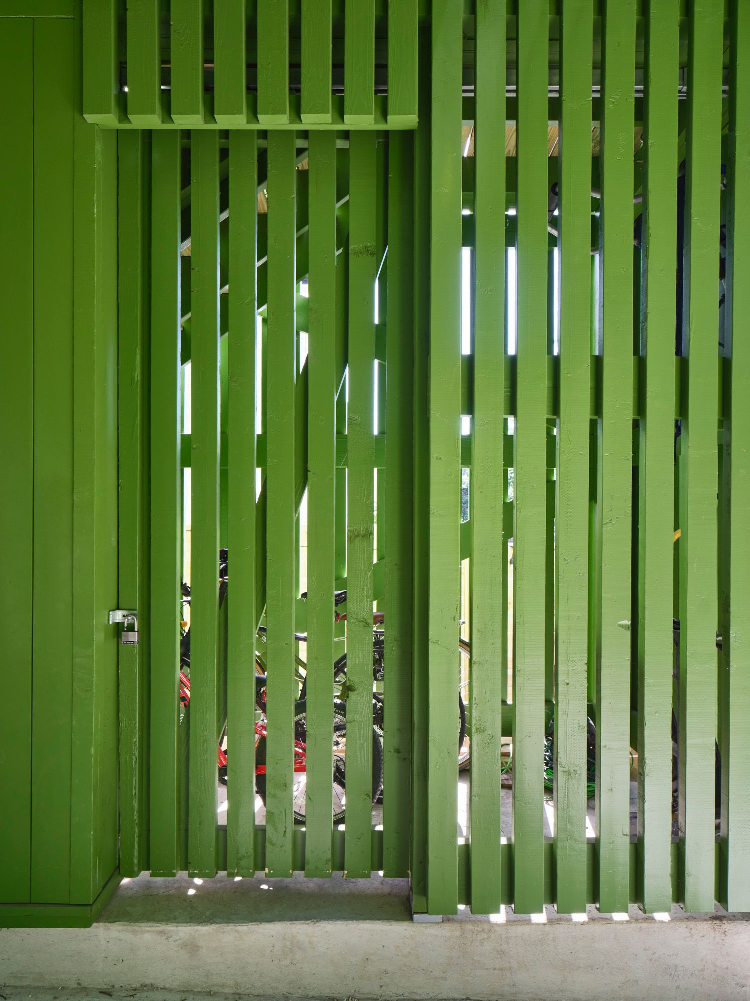 Bicycles stored behind a locked wooden slat enclosure